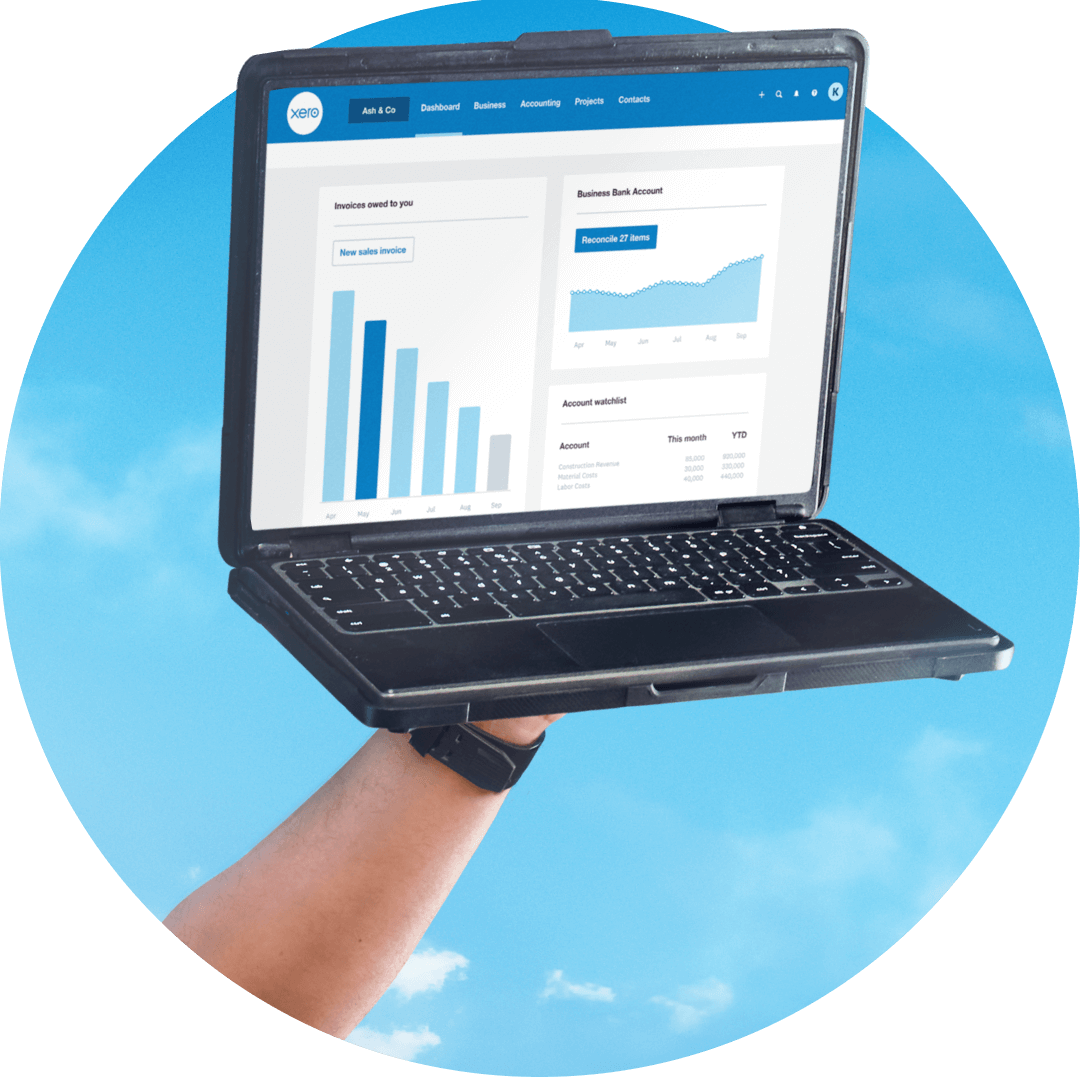 A hand holds a laptop with the Xero dashboard on display.