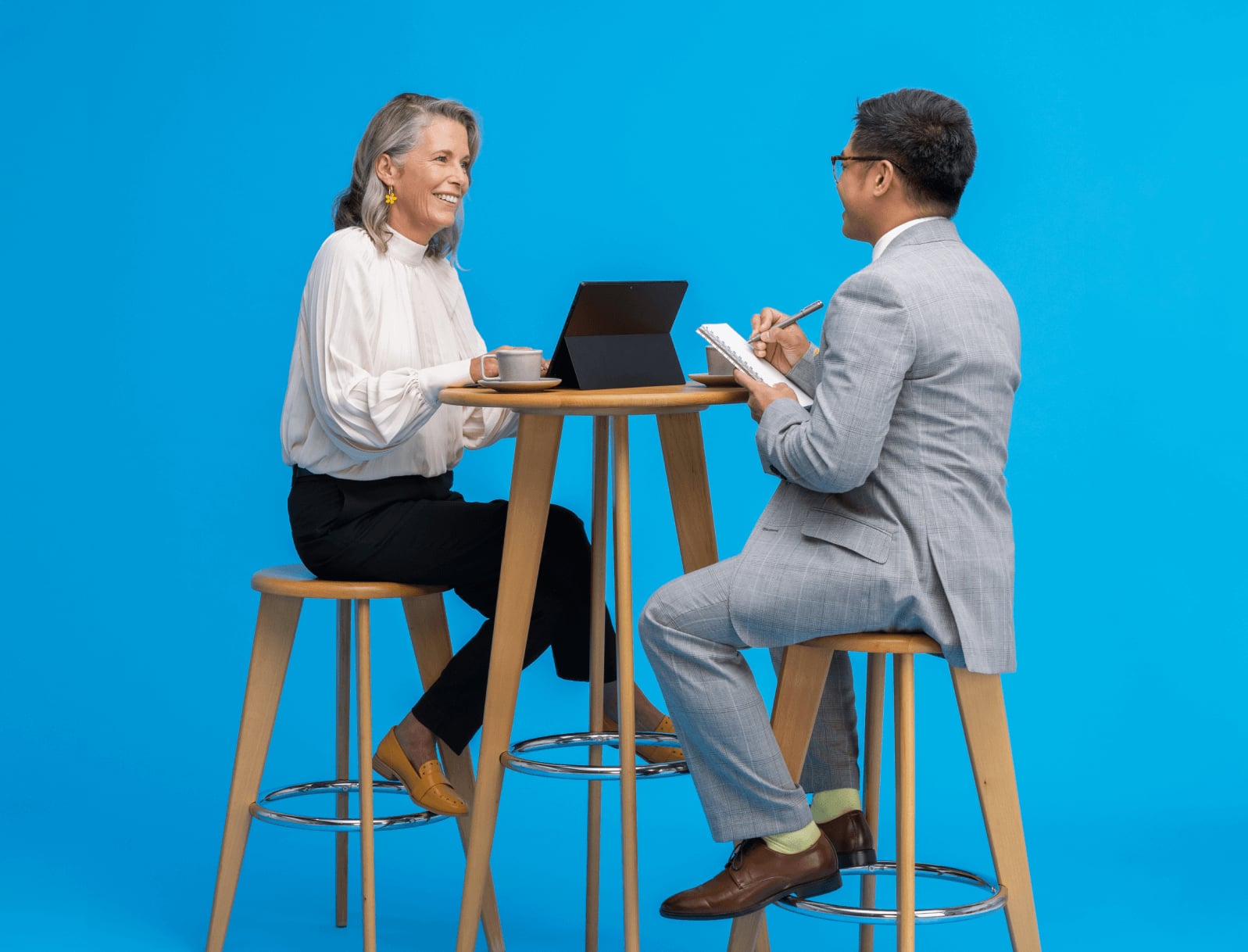 Two smartly dressed people meeting in blue space