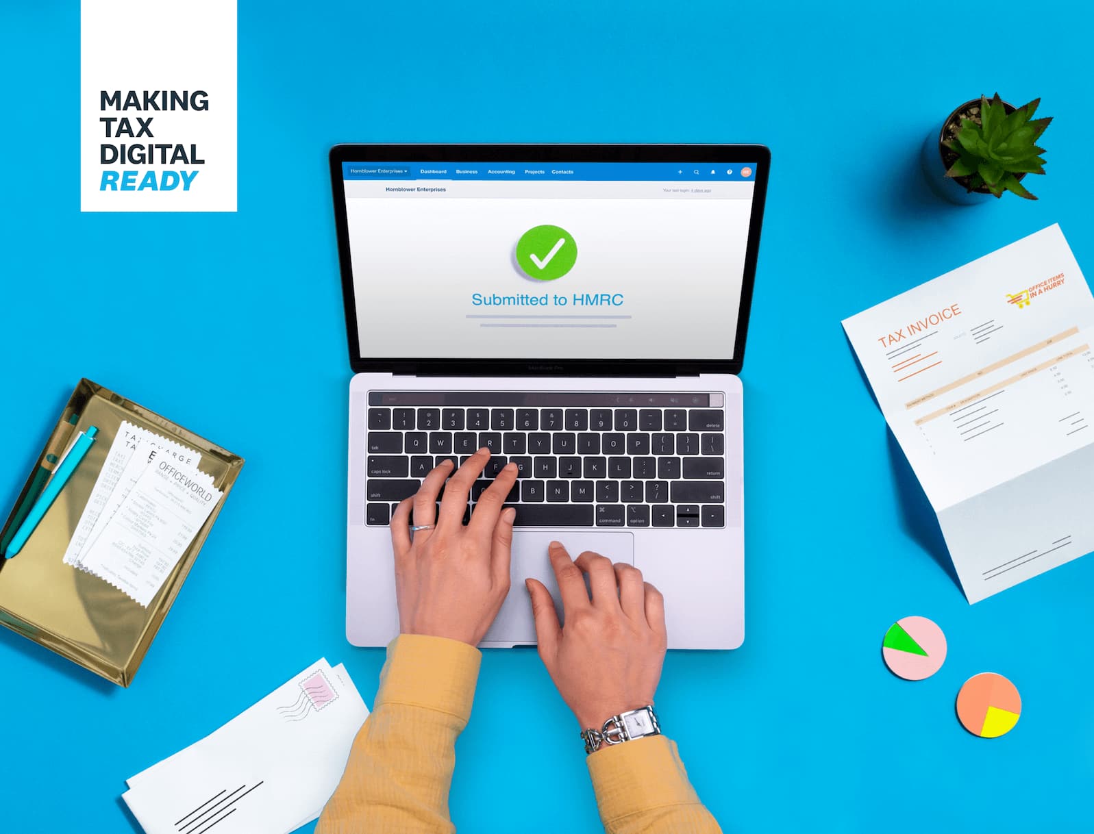 Hands typing on a laptop showing a green tick and text "Submitted to HMRC".