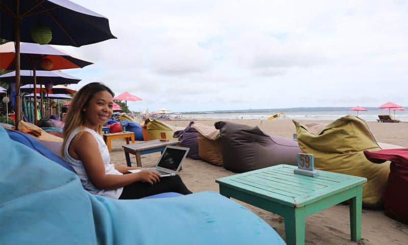 Cicih Setiawati of BukuBuku working on her laptop computer at a beachside cafe.