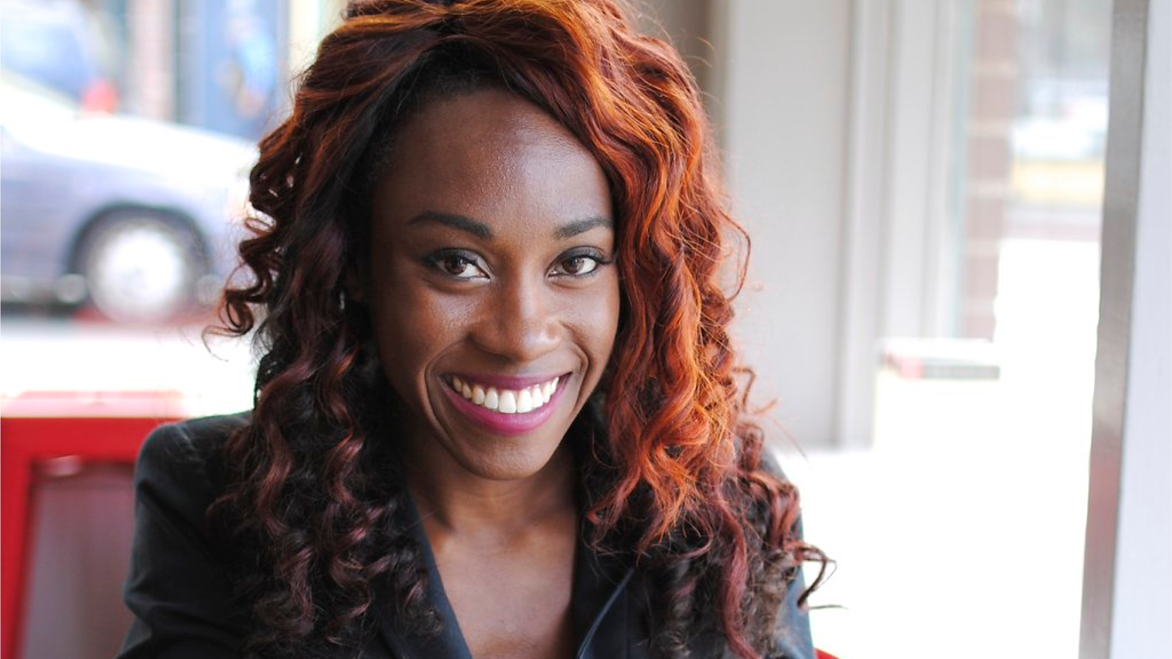 Head and shoulders of consultant Danetha Doe sitting at a cafe.