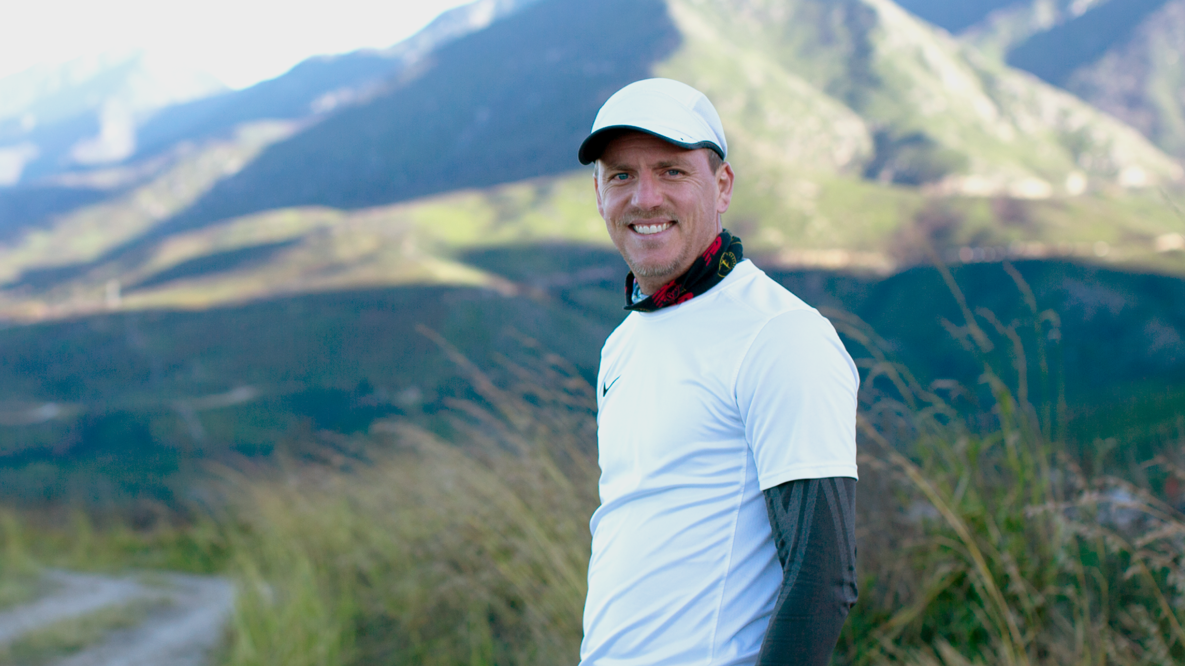Willem Haarhoff, co-founder of DoughGetters accounting firm, stands in front of a mountain backdrop wearing sports clothing.