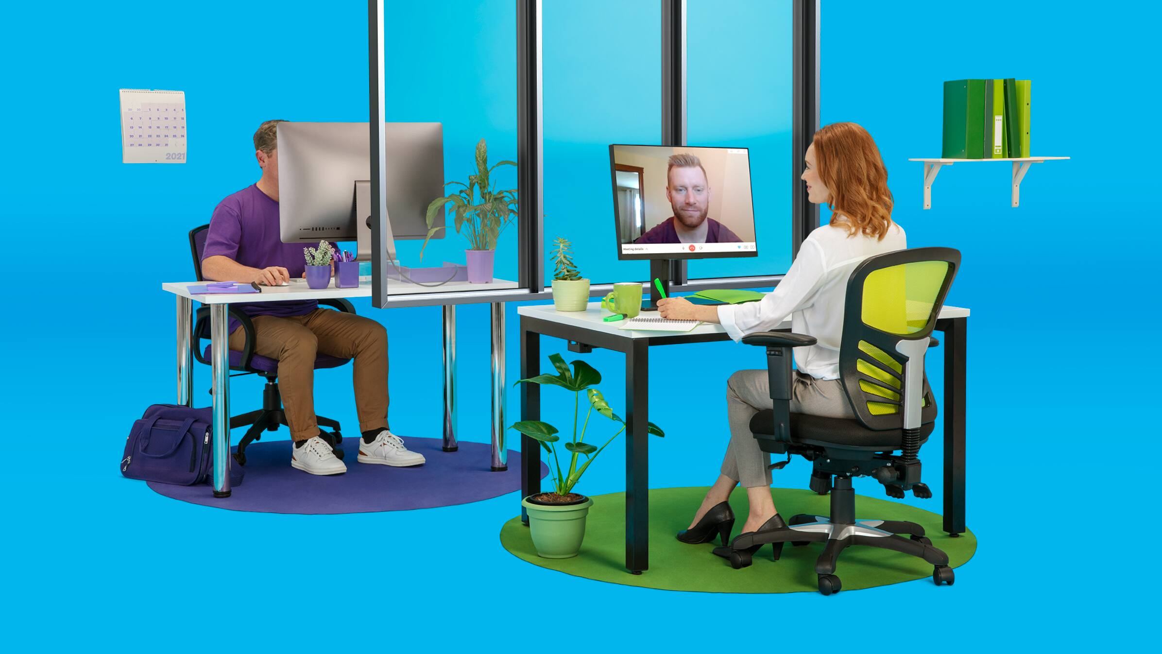Two people on a blue background work on their desks and computers that sit facing each other.