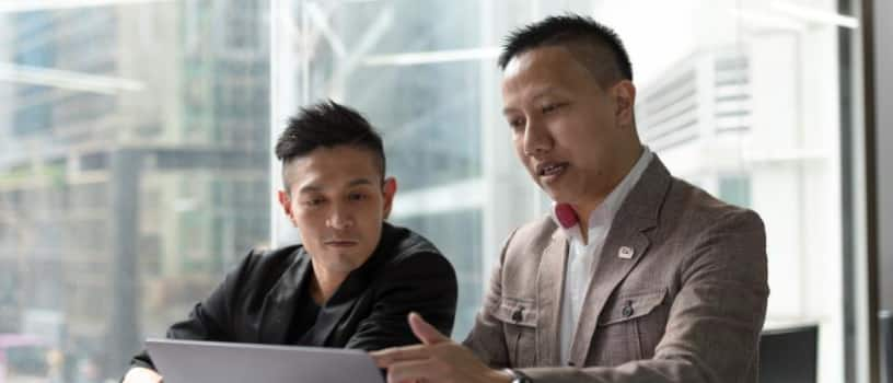 Rex Leung working on a laptop computer with a colleague at Linkers CPA.