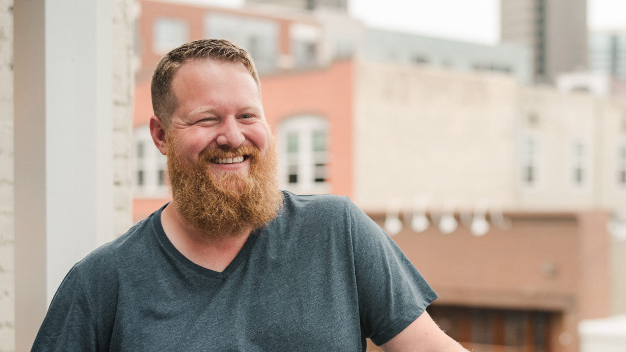 Chad Davis, co-founder of virtual accounting firm LiveCa, stands on a balcony smiling.