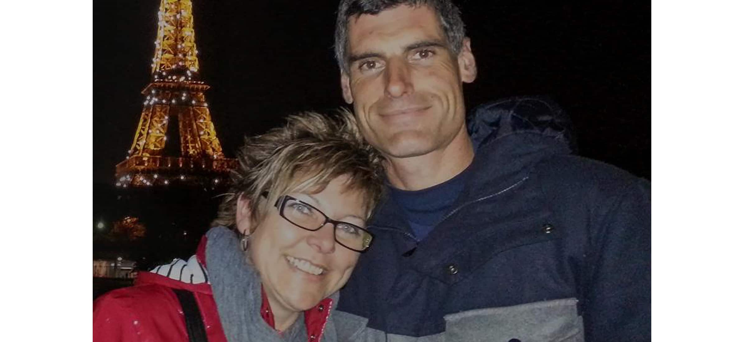 Di Crawford-Errington and husband Paul Errington in front of the Eiffel Tower at night time.