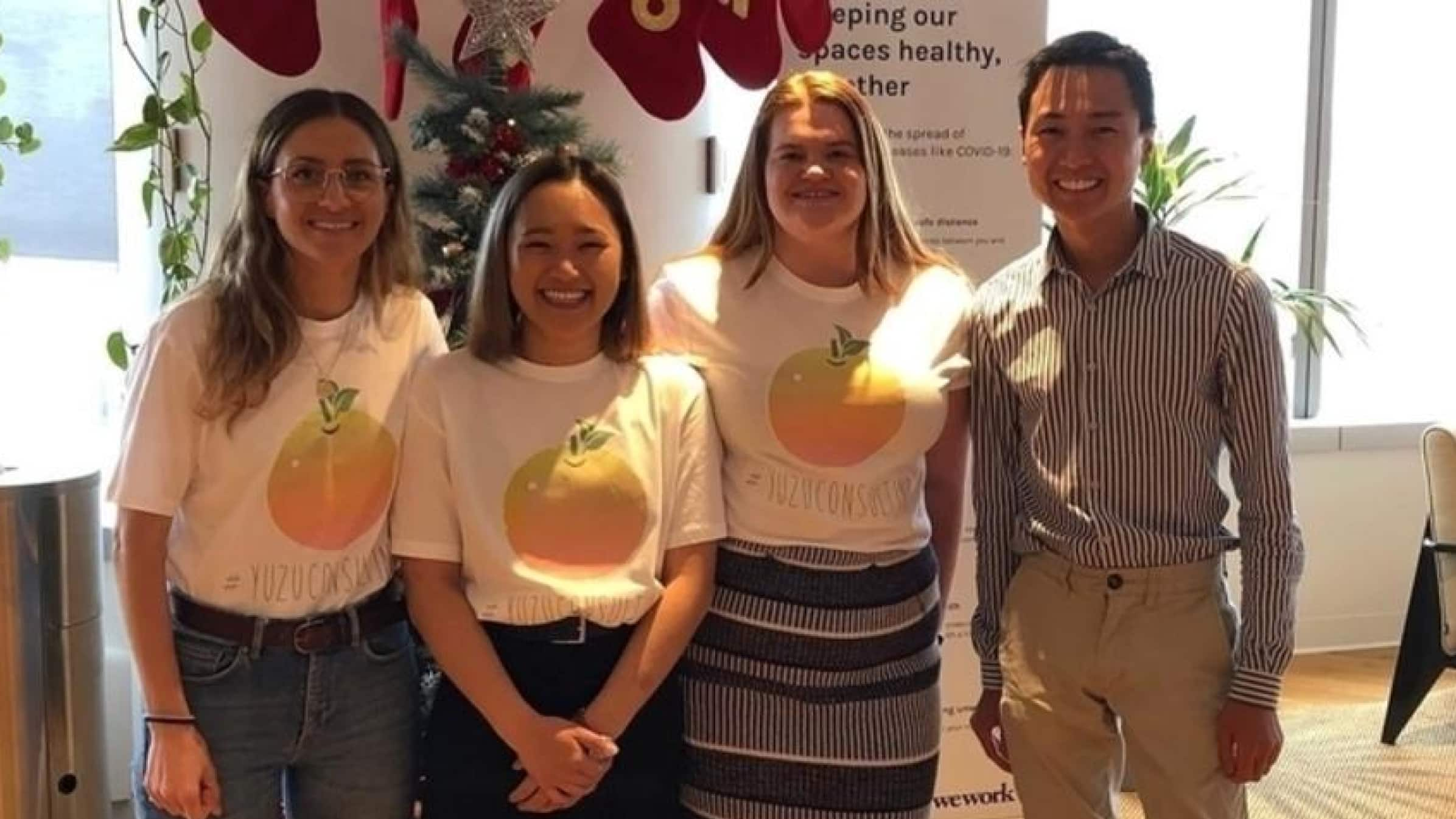 Jay Shong standing with three colleagues in the Red Beak International offices.