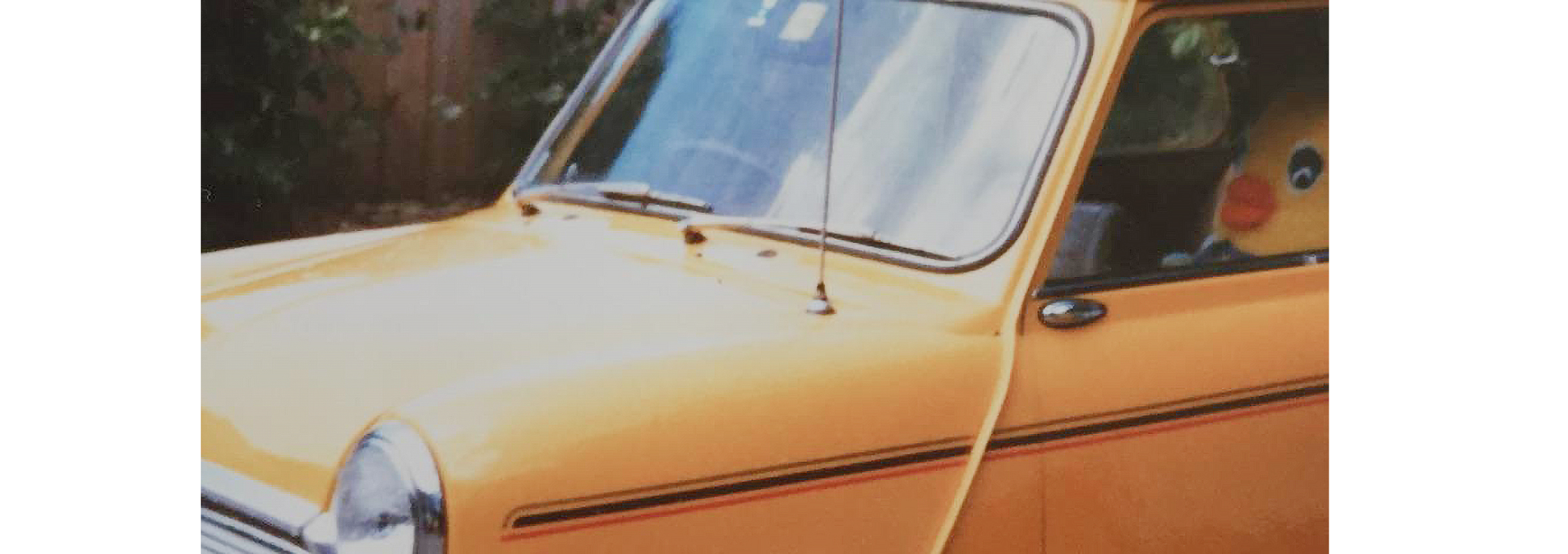 A retro photo close up on a yellow car.