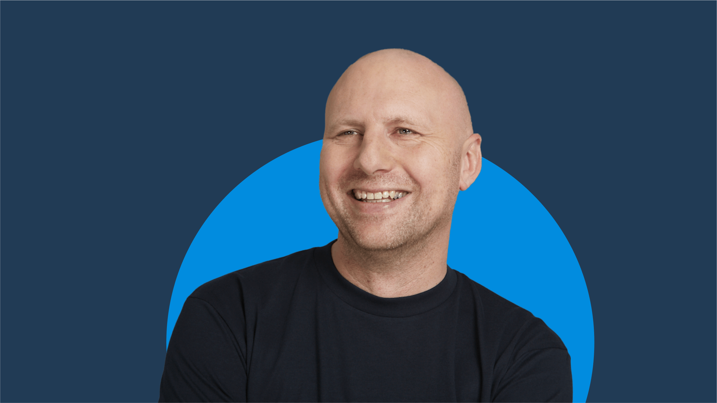 Head and shoulders of Allan Davidson smiling to camera against a blue background.