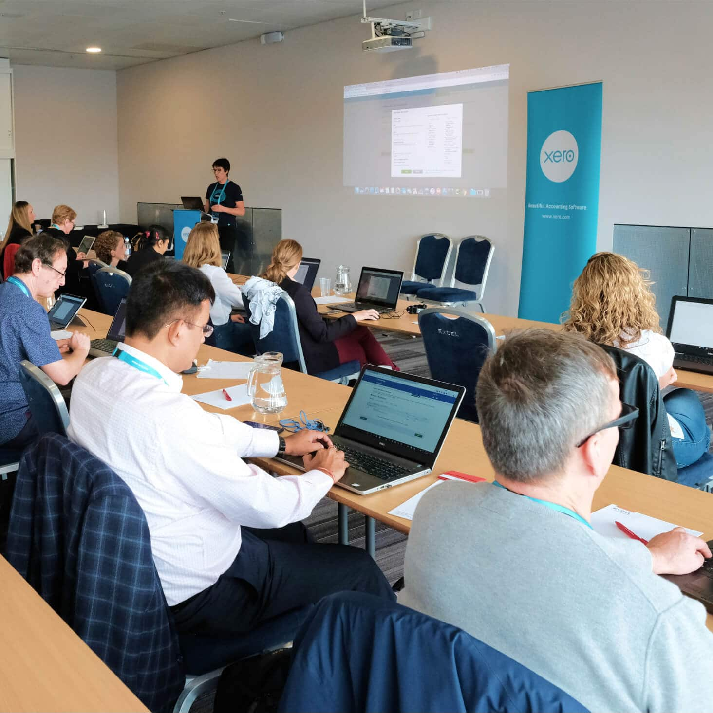 A group of students sit in a lecture theatre, taking in a lesson on cloud-based accounting software.