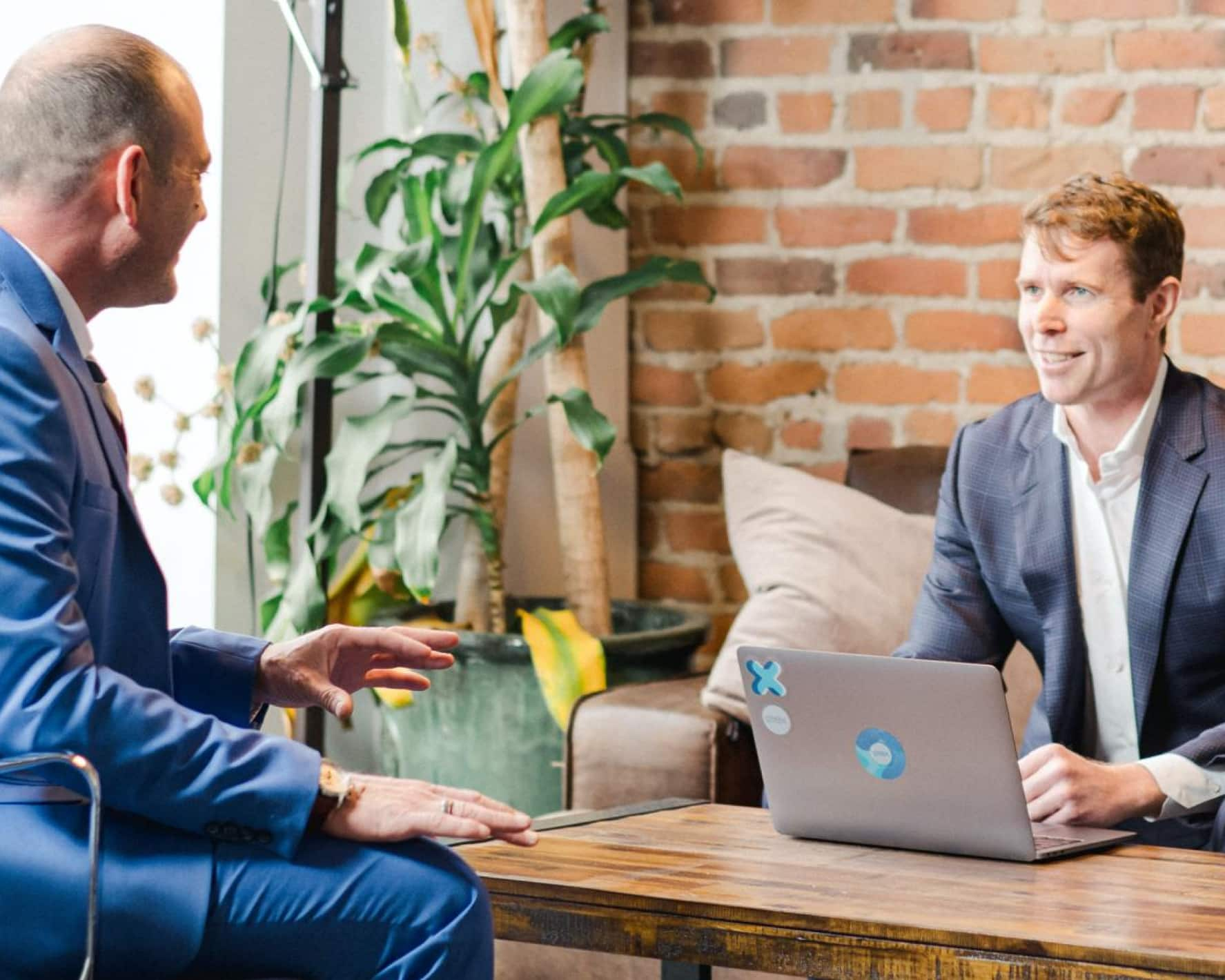 Two accountants speaking, with a laptop with Xero stickers