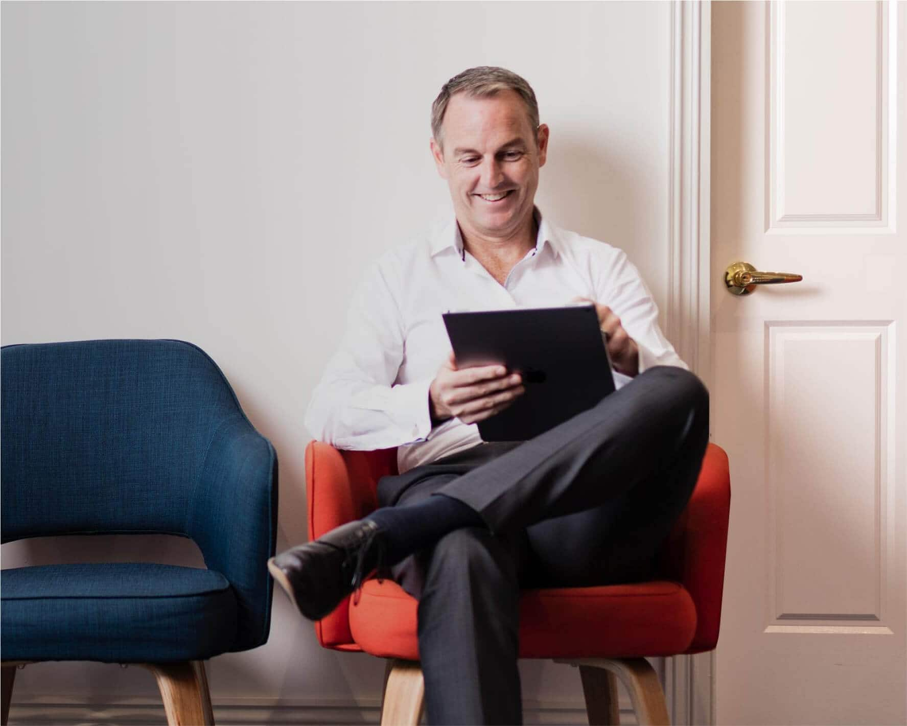 A client uses their tablet while waiting in a medical clinic to see a healthcare professional.