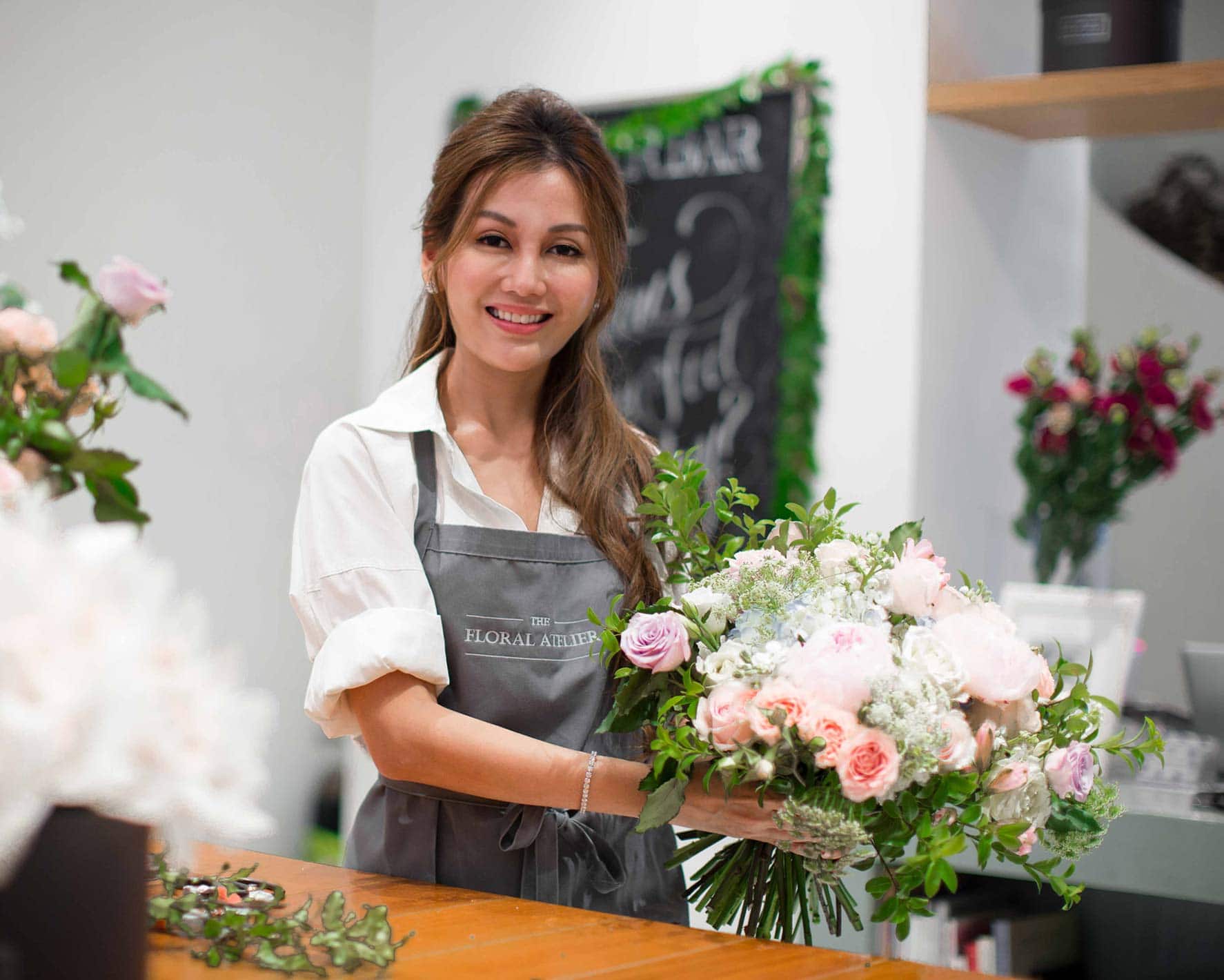 A person arranging flowers in a store.