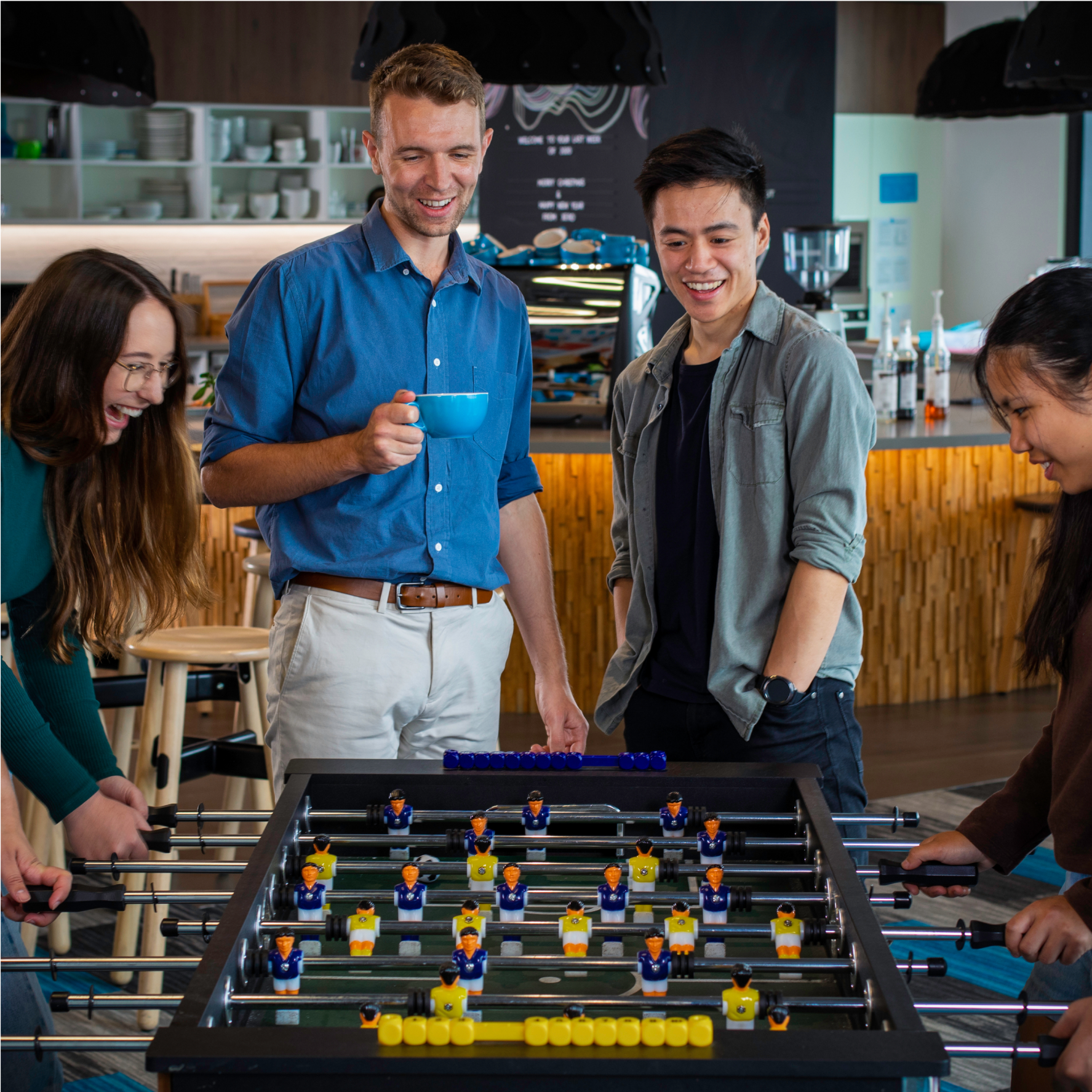 Xero grads play table football while having coffee.