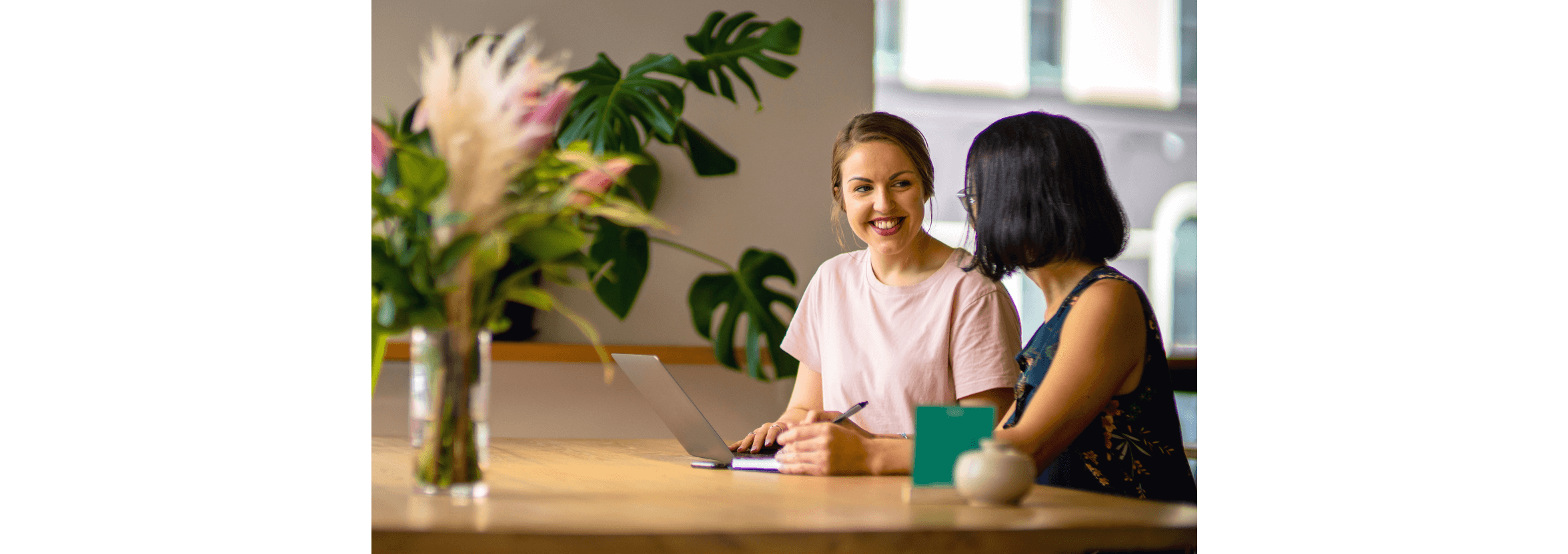 A Xero employee and charity worker at a desk with a laptop open in front of them.