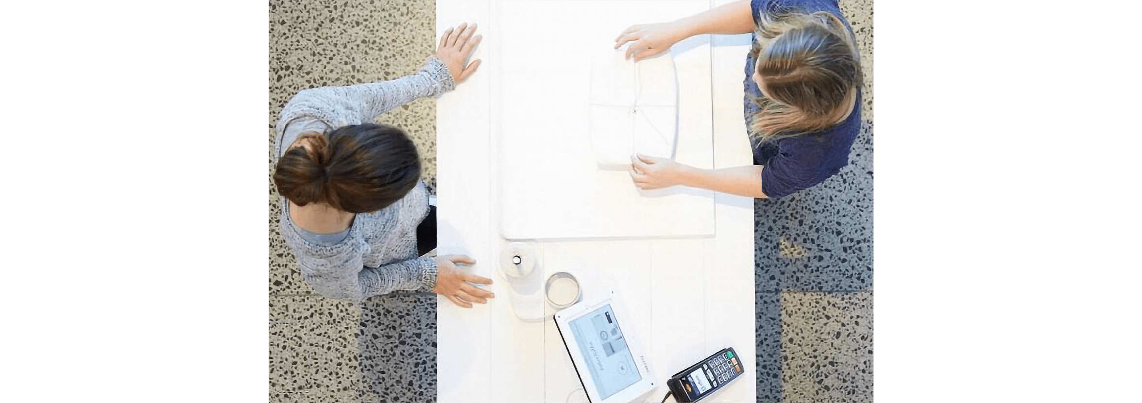 Two people standing at a desk review business performance metrics.