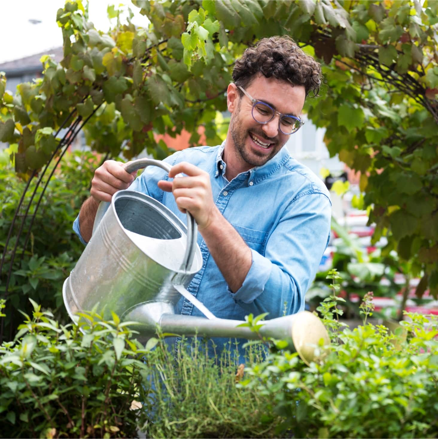 A person watering their vegetables.