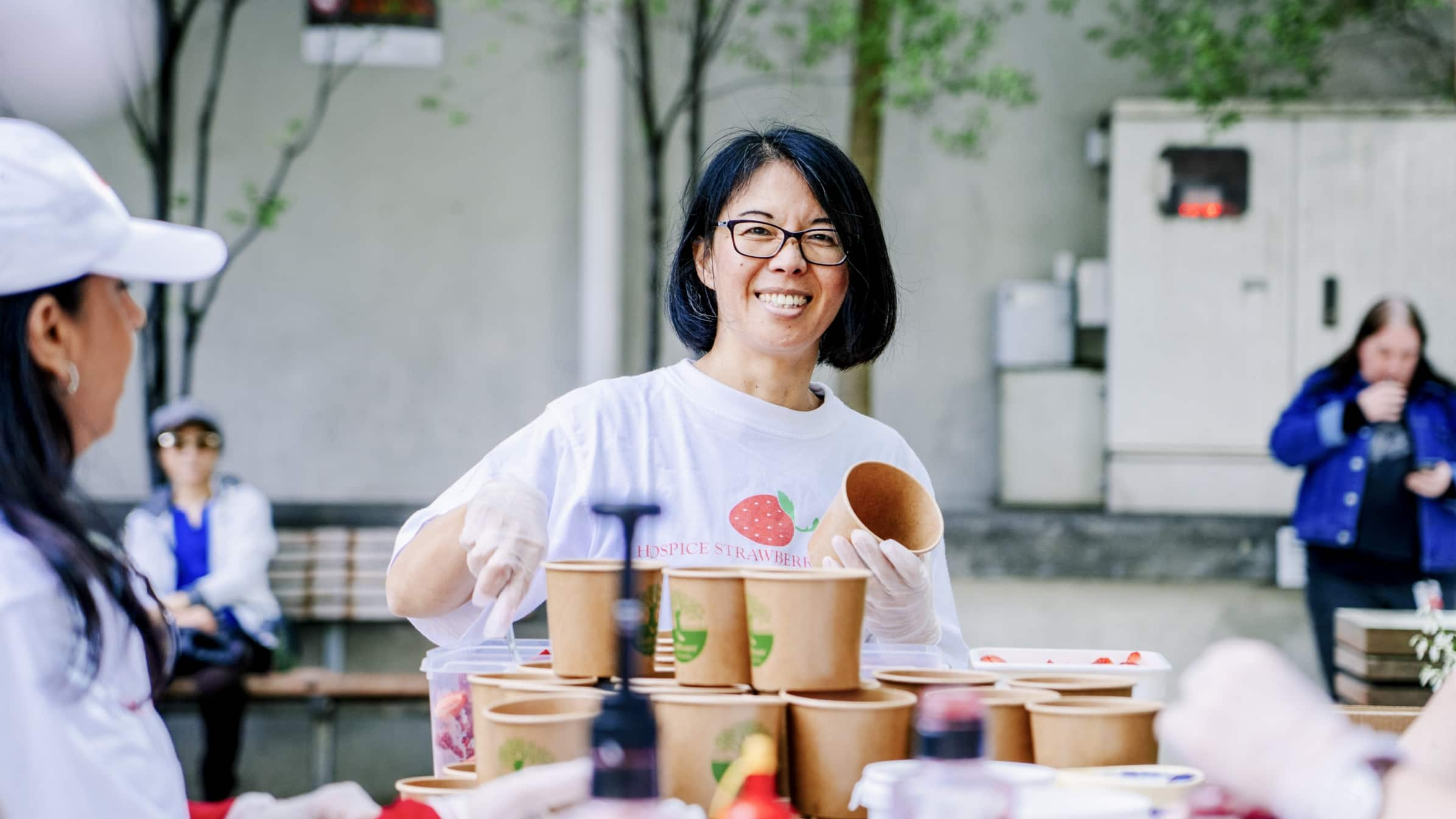 A Xero staff member smiling while serving food at a volunteer day.