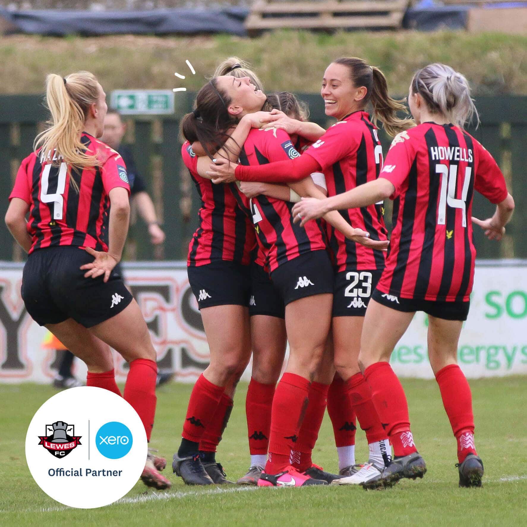 Women players from Lewes FC give a congratulatory hug to a teammate who has just scored a goal.