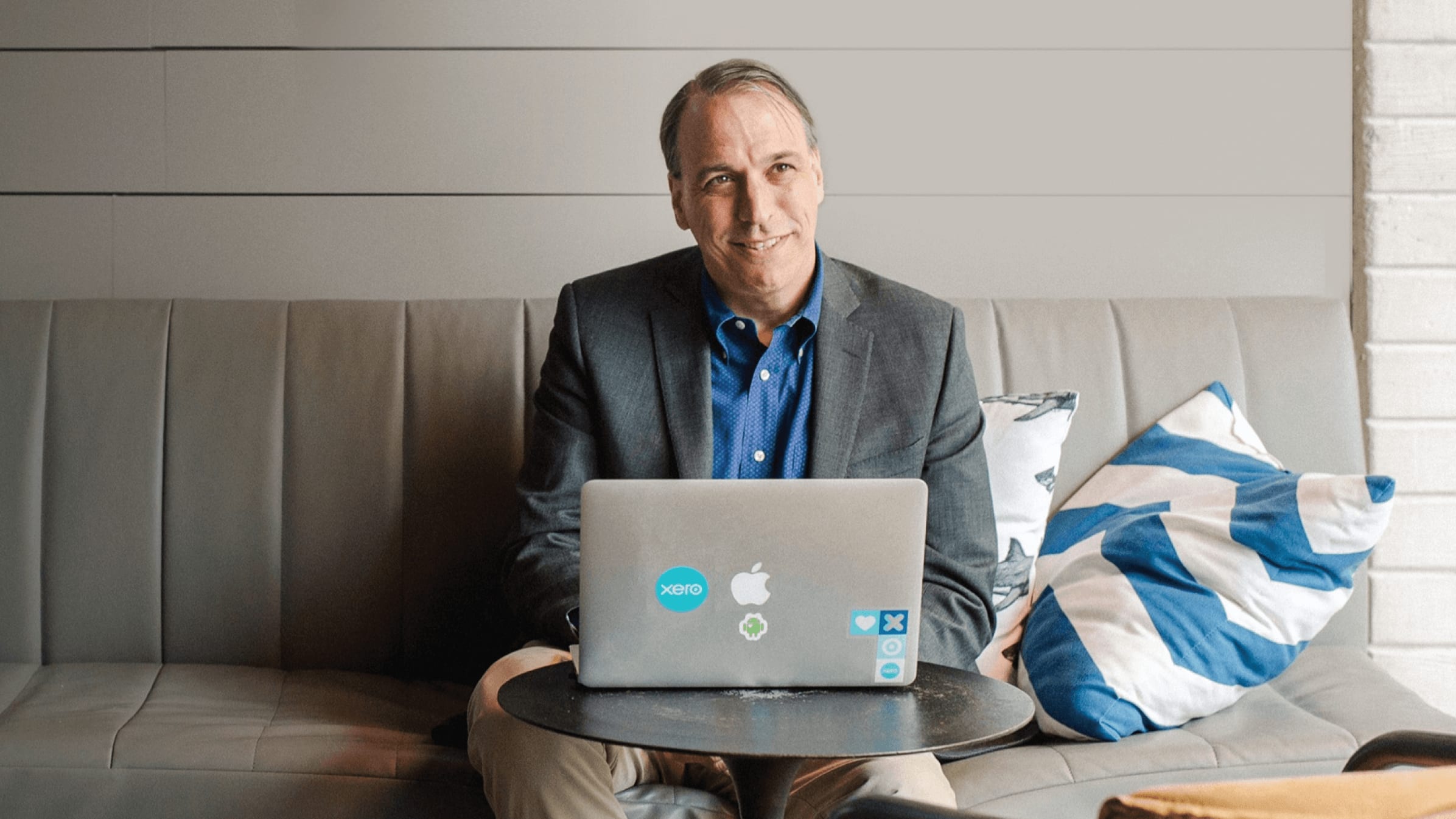 An accountant smiling while sitting in front of their laptop.