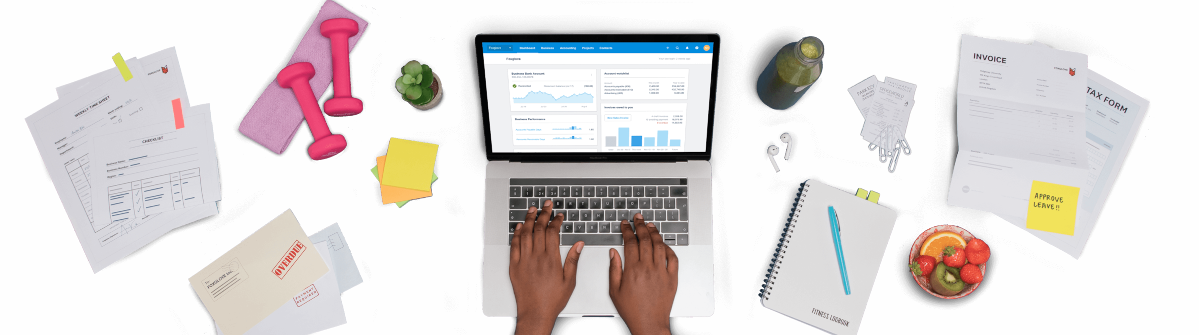 A pair of hands working on a laptop surrounded by invoices, bills, receipts and tax returns.