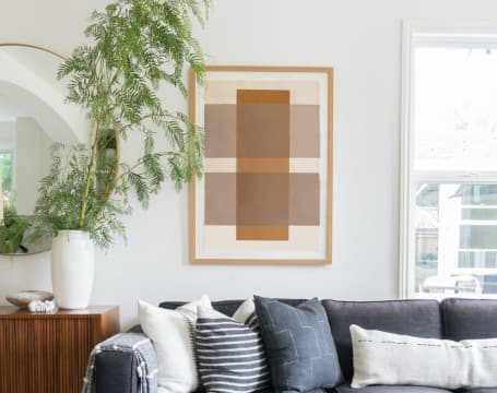 living room with couch, tree, and wall art