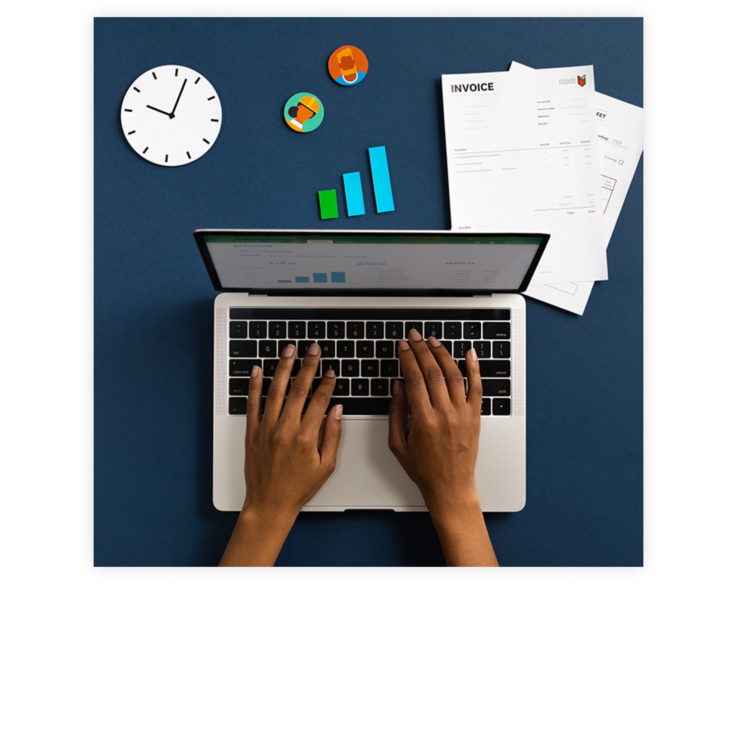 Hands on a laptop working at a table with and invoices, clock and graph in the background