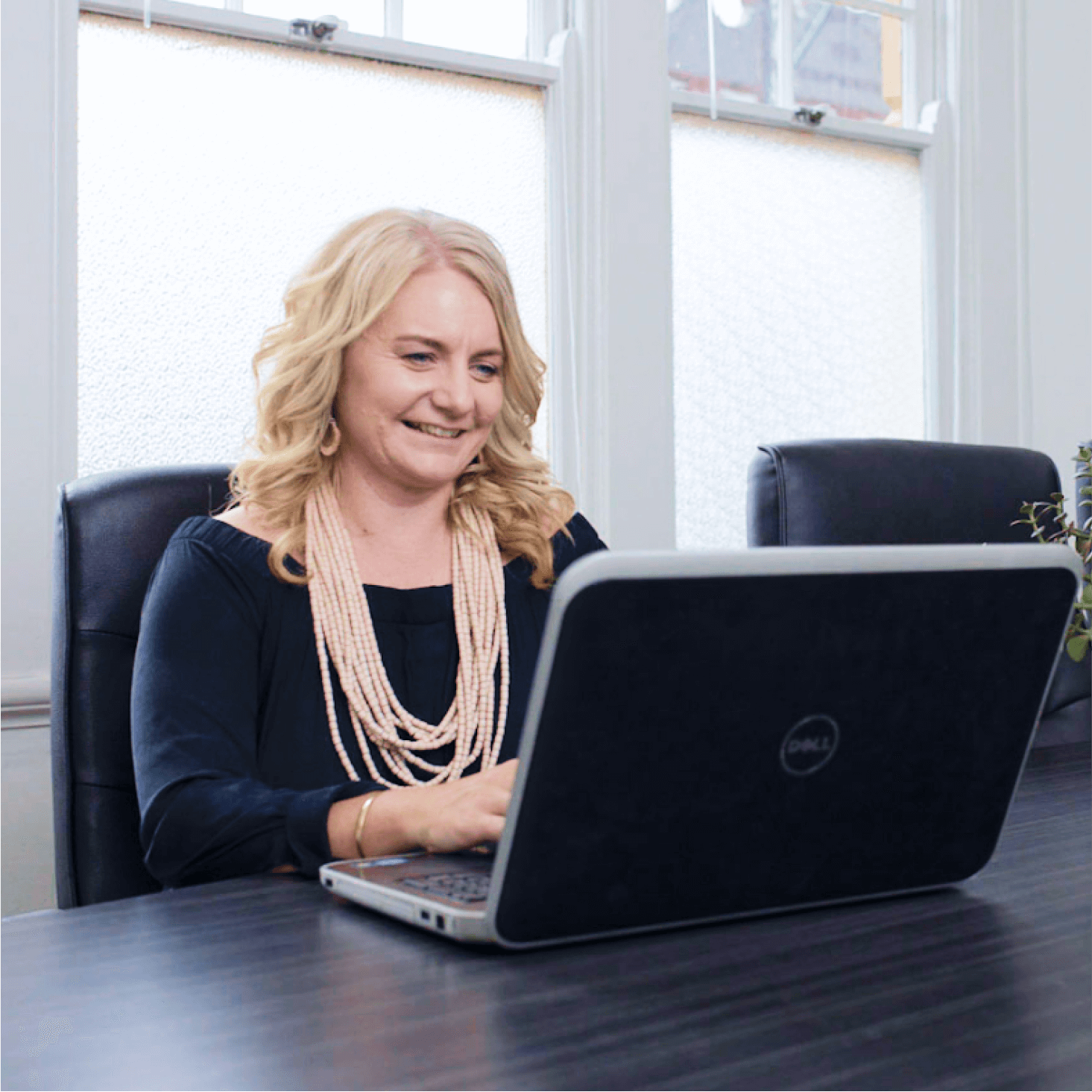 A small business owner at their laptop, happy to have their finances clearly in one place with Xero.