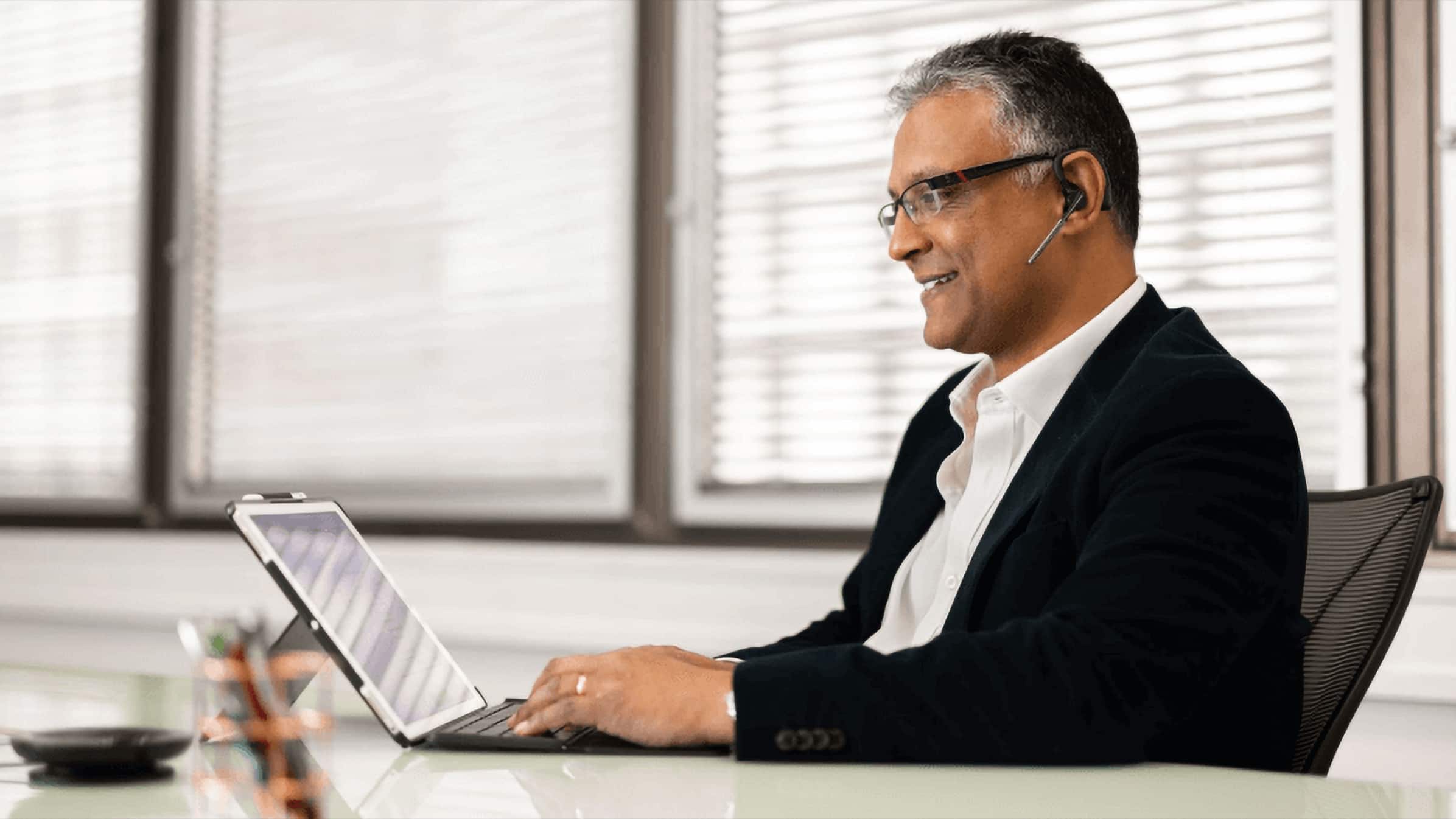 An accountant sits at their desk using their laptop to submit tax filings with Xero’s MTD-compatible tax software.