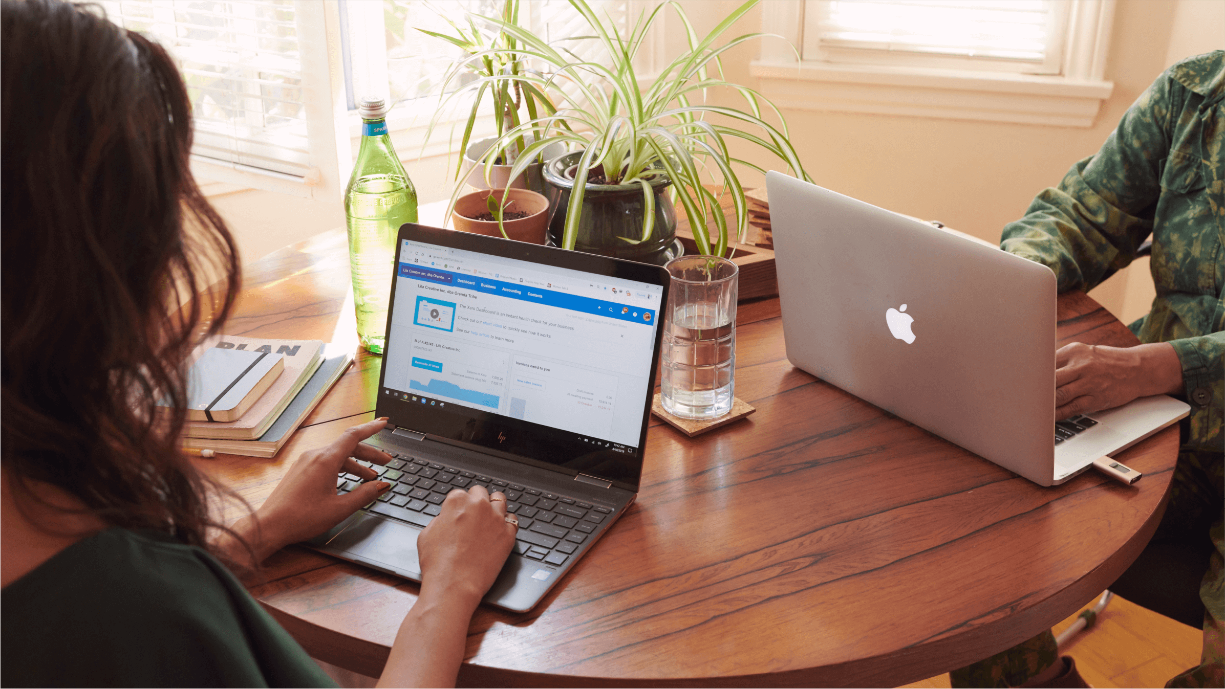 An accountant sits at their laptop opposite their business partner, looking over the features of Xero’s partner programme.