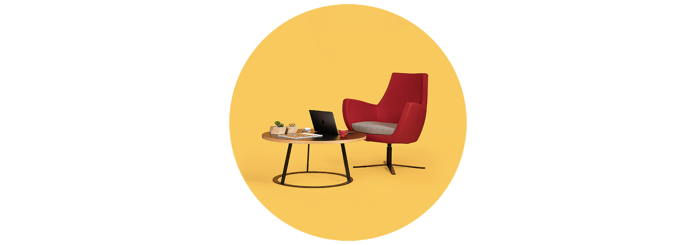 A comfortable chair and circular coffee table being used as a casual workspace at Rewired.