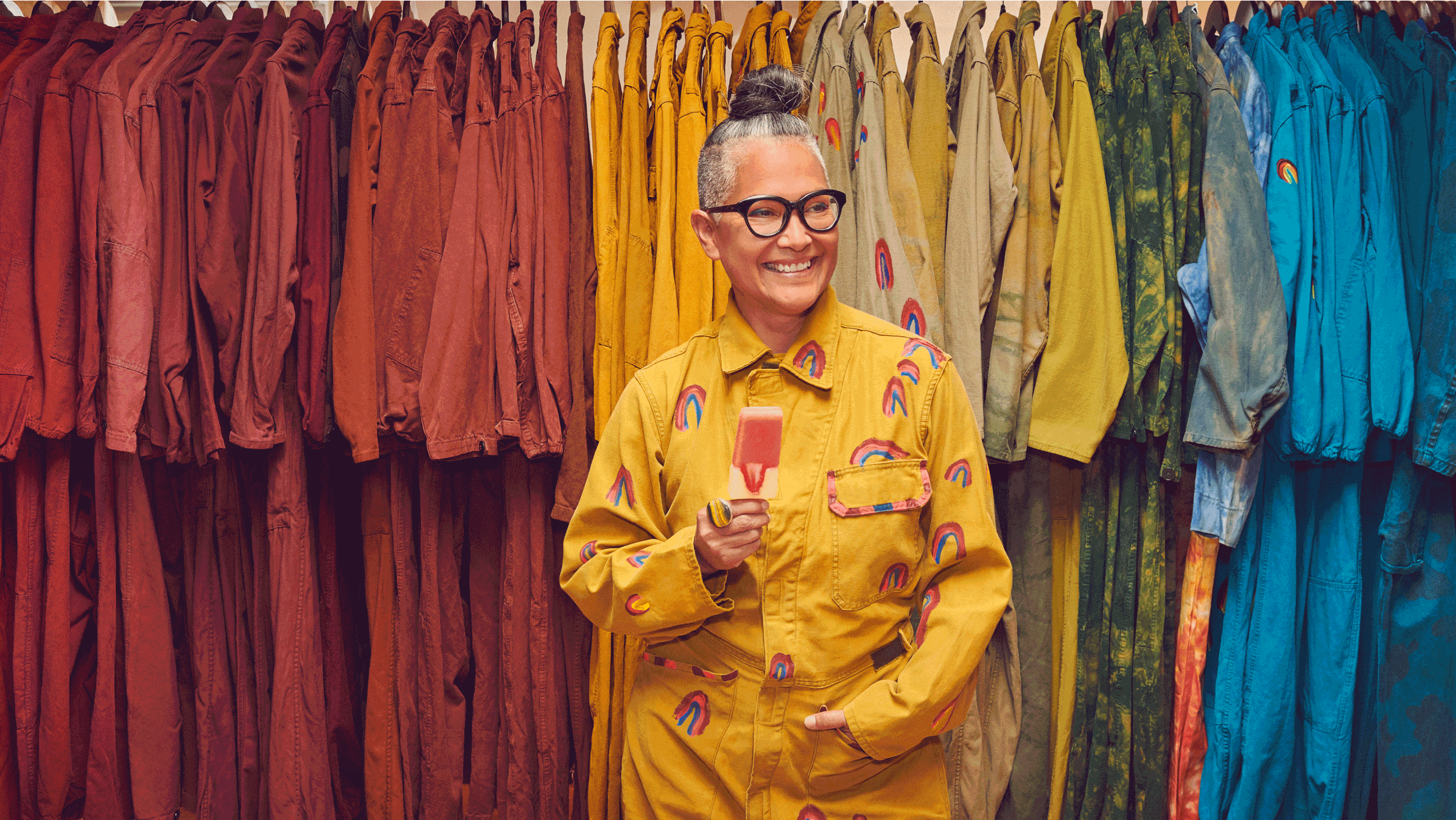 Amy Yeung, founder of fashion brand 4Kinship, stands in front of a row of dresses