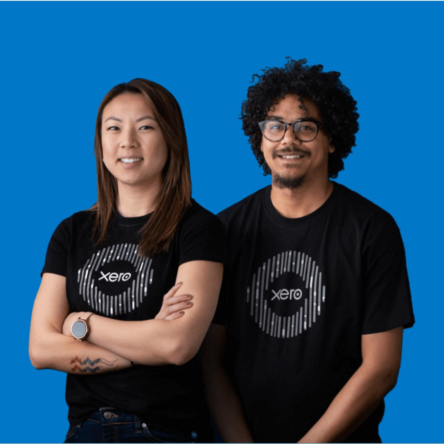 Two members of the Xero team smiling, wearing black Xero t-shirts.
