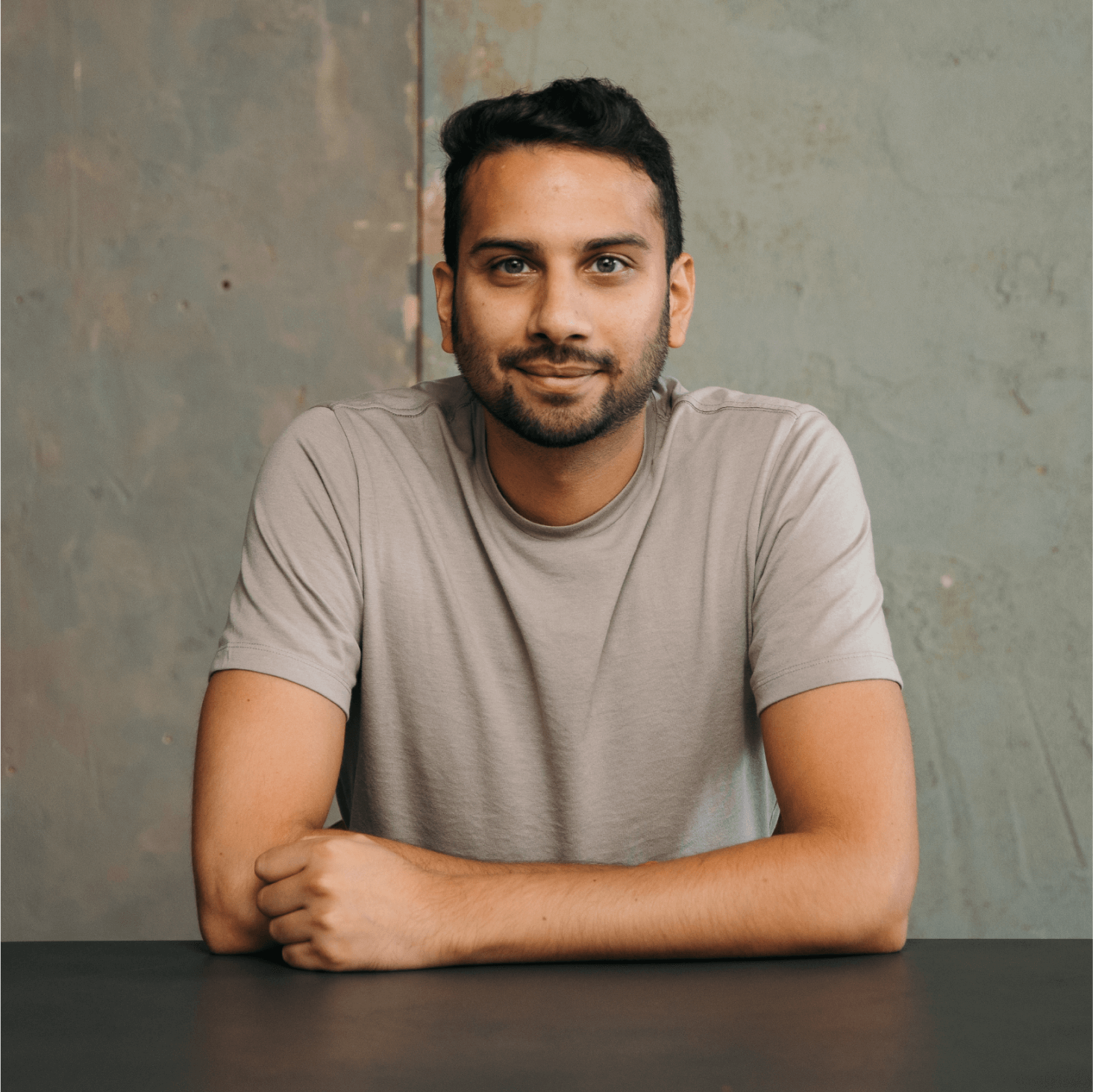 Paras Shah, workflow manager at DSK Partners, is seated with his arms on top of a desk.