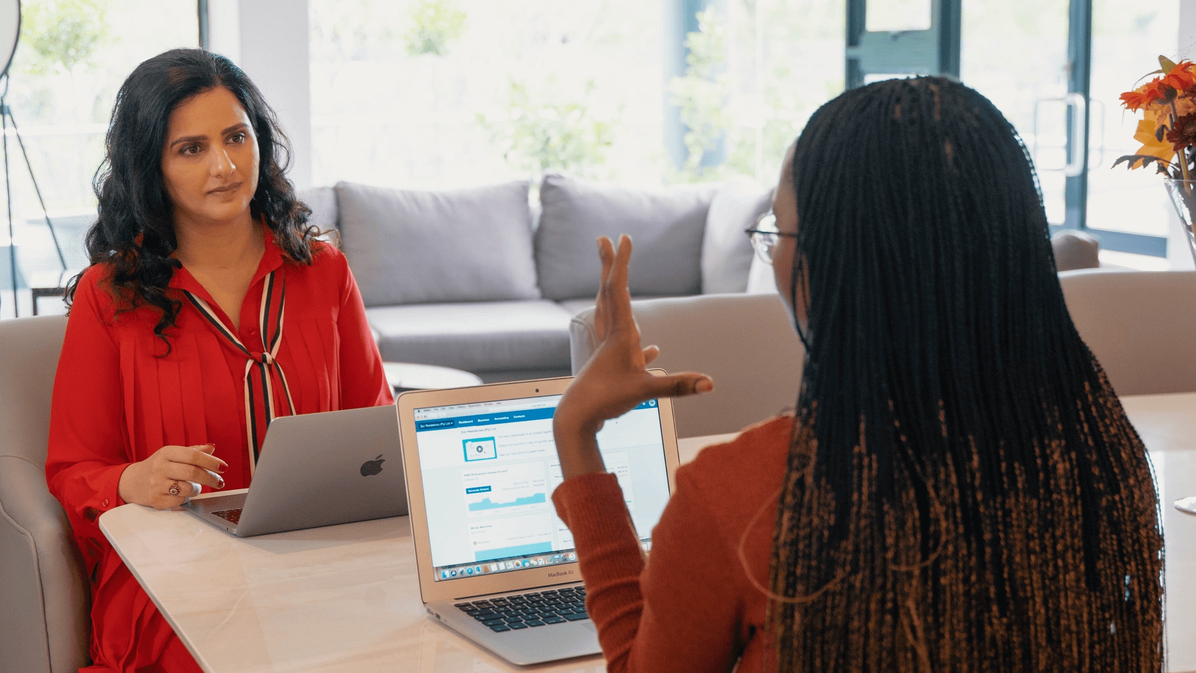 A cloud integrator and a factory owner look at a tablet as they discuss what solutions the business needs. 