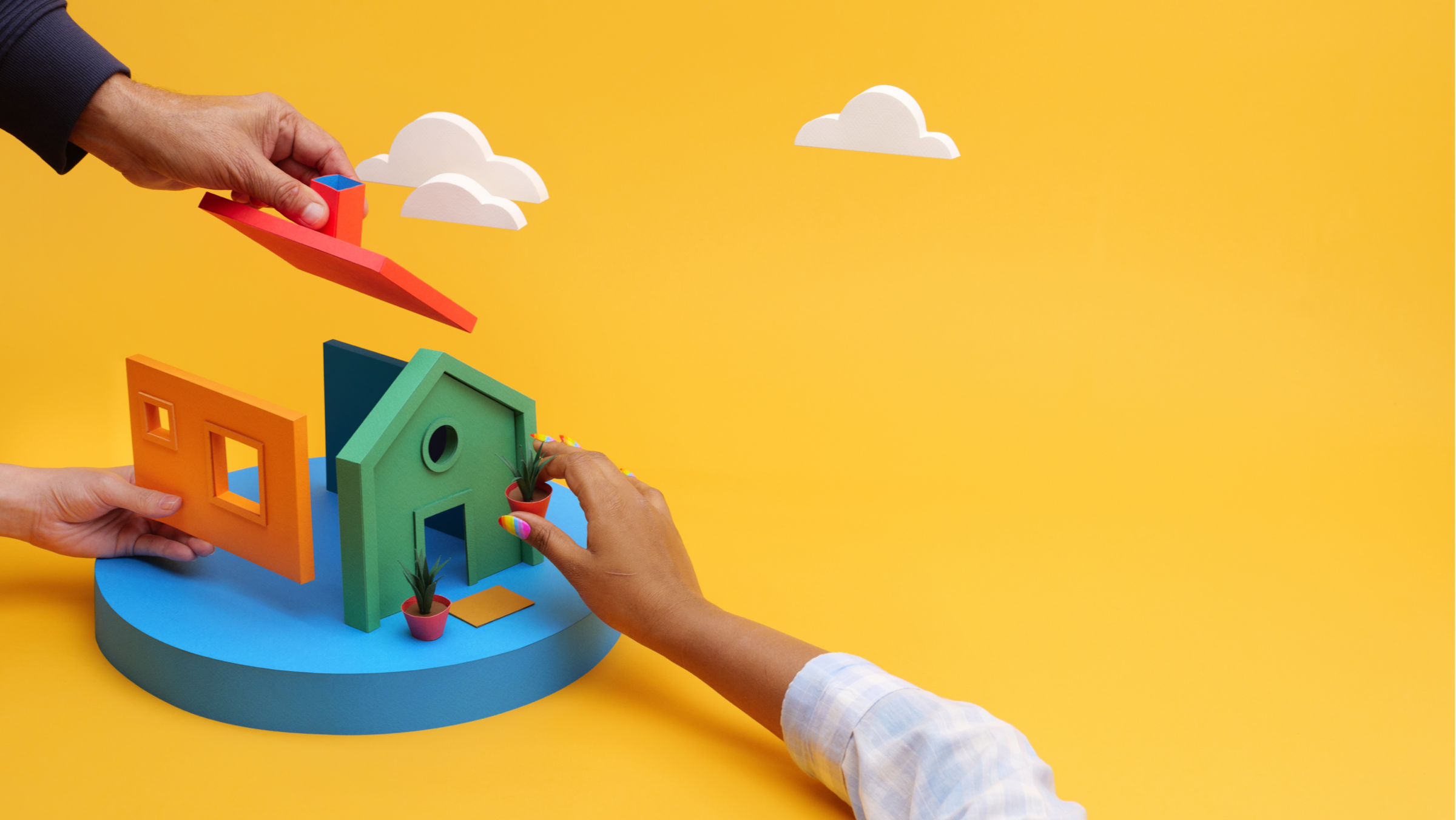 Hands building a little house