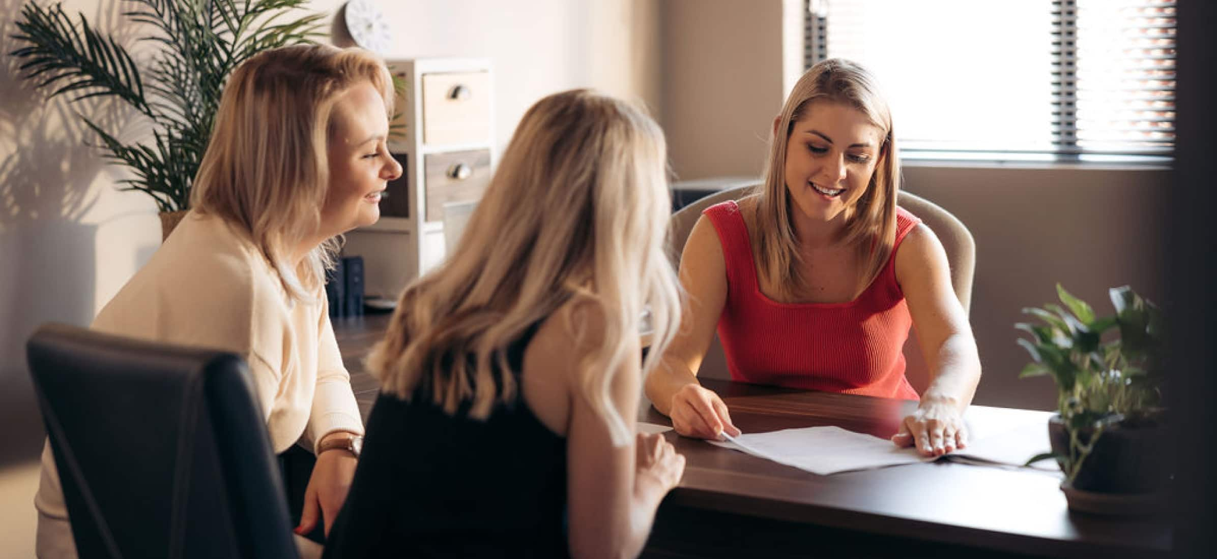 Mariaan working with colleagues at desk.