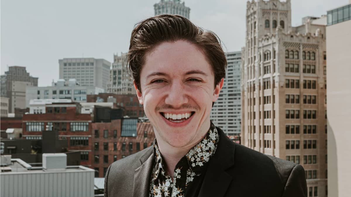 Lead Accounting Technologist Dan Quigley from MATAX stands on rooftop with city in background