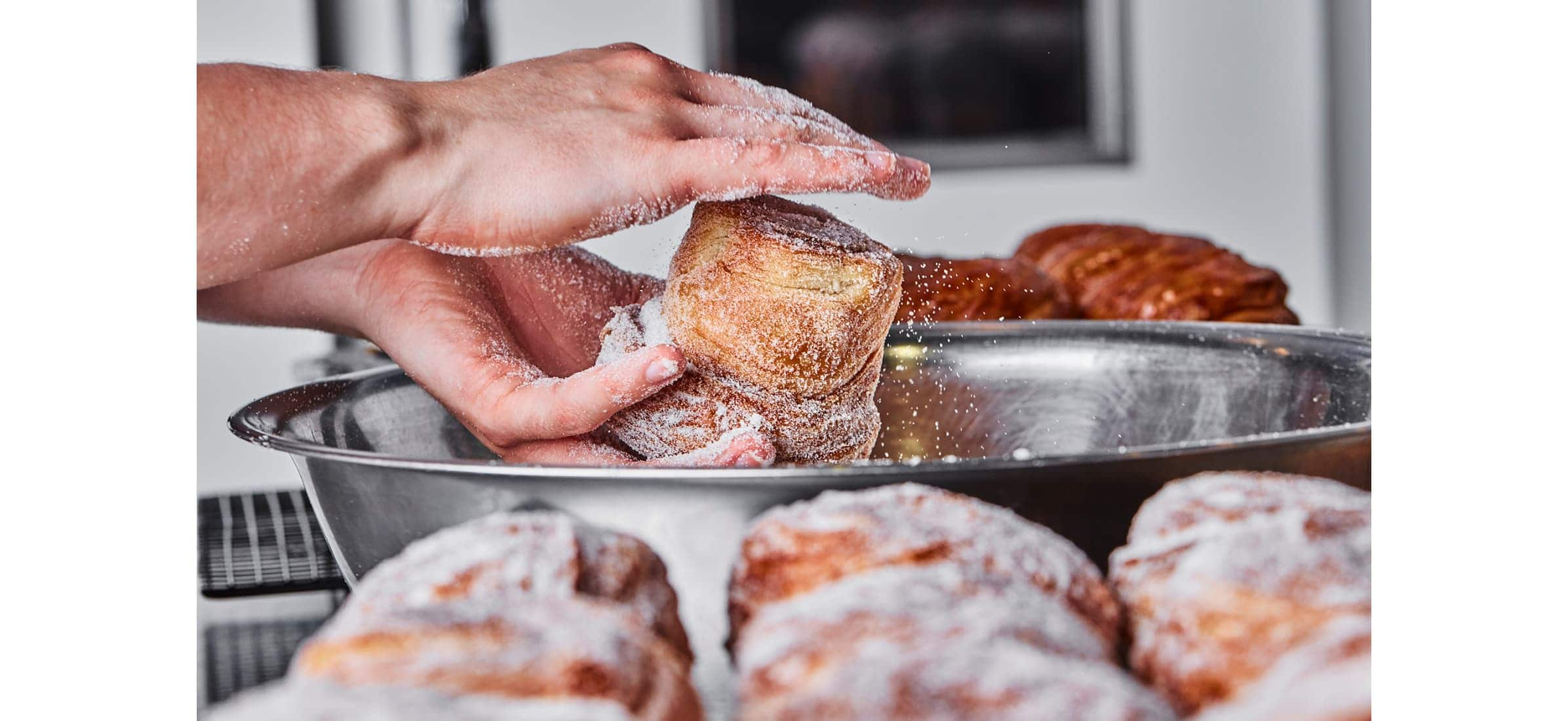 A close-up of hands preparing pastry dough in a bowl.