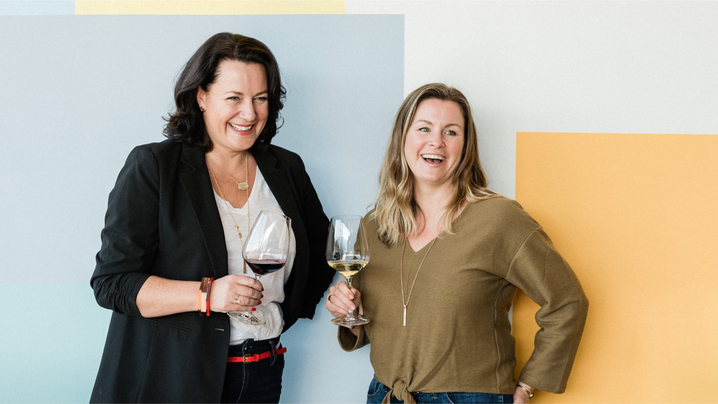 Nicole Hughes and Anne Siegel, owners of Olive and Poppy, laughing over a glass of wine.