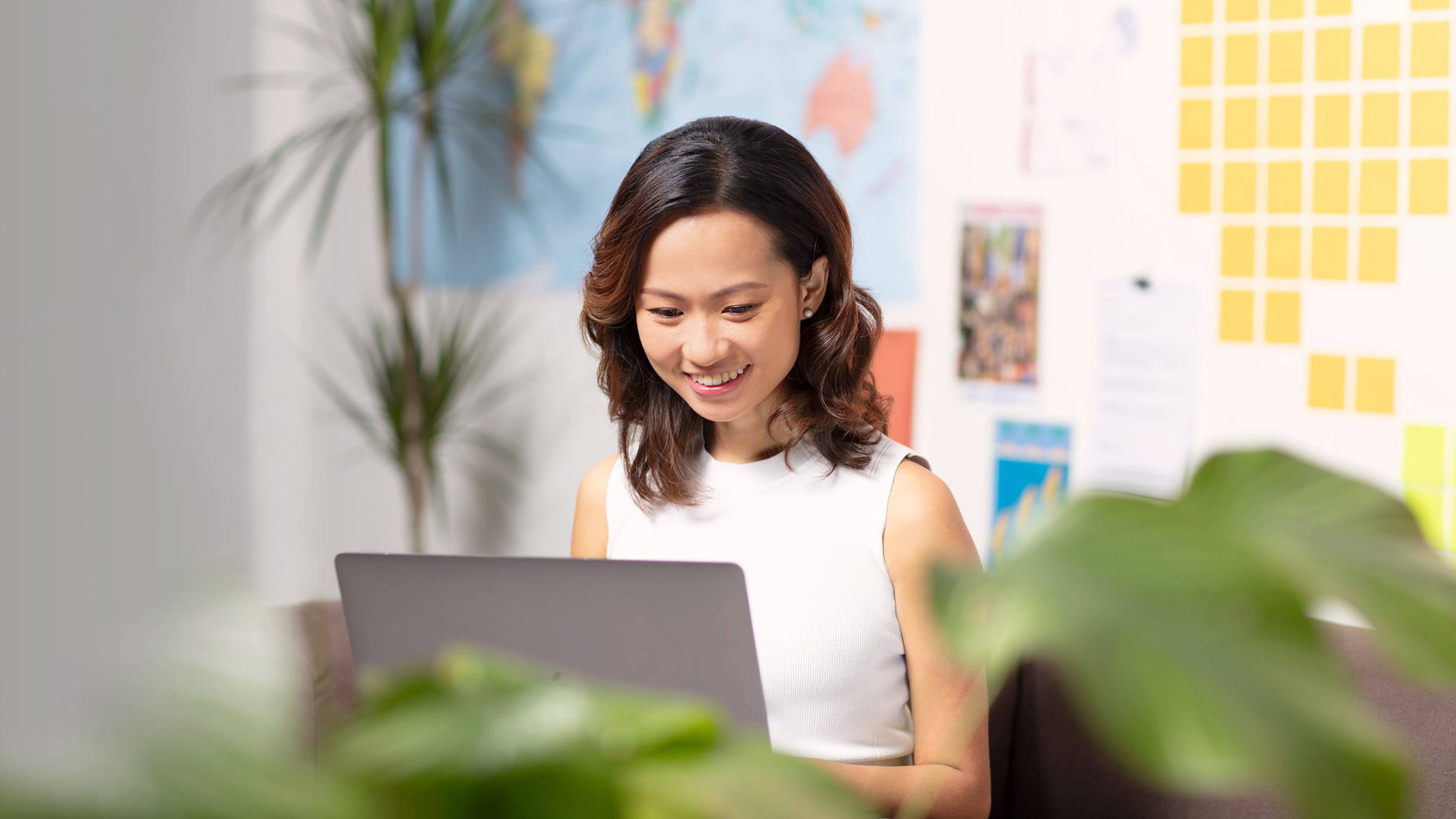 Zelia Leong, co-founder of Anywhr, sitting in her office at her computer and desk.