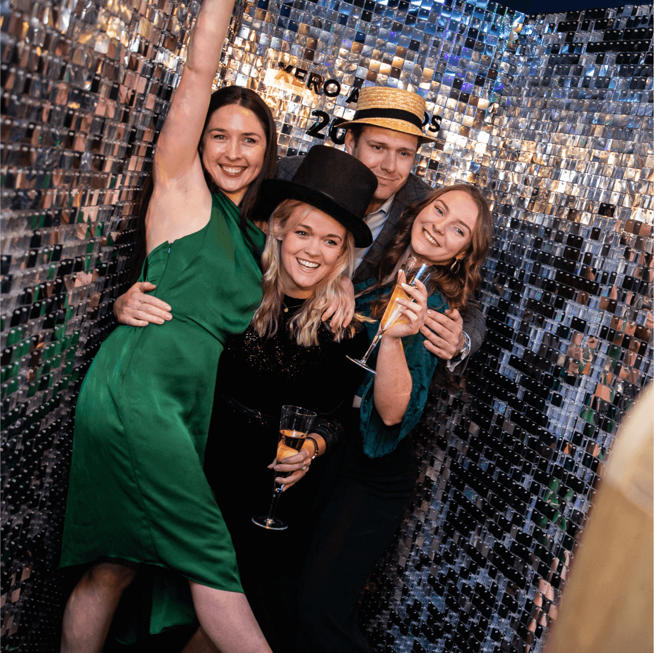 Four people, two holding a glass of champagne, celebrate at the Xero Awards ceremony. 