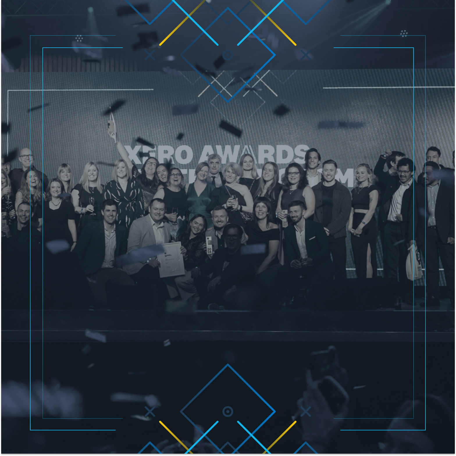 A group of award winners celebrating on stage.