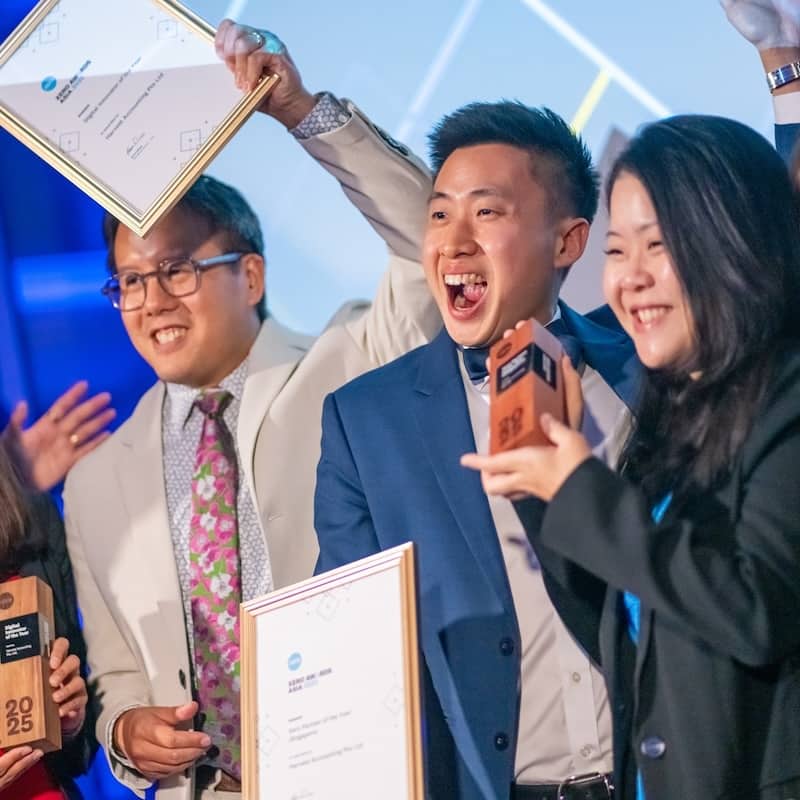 Harvest Accounting team on stage holding up their trophies and winner’s certificate.