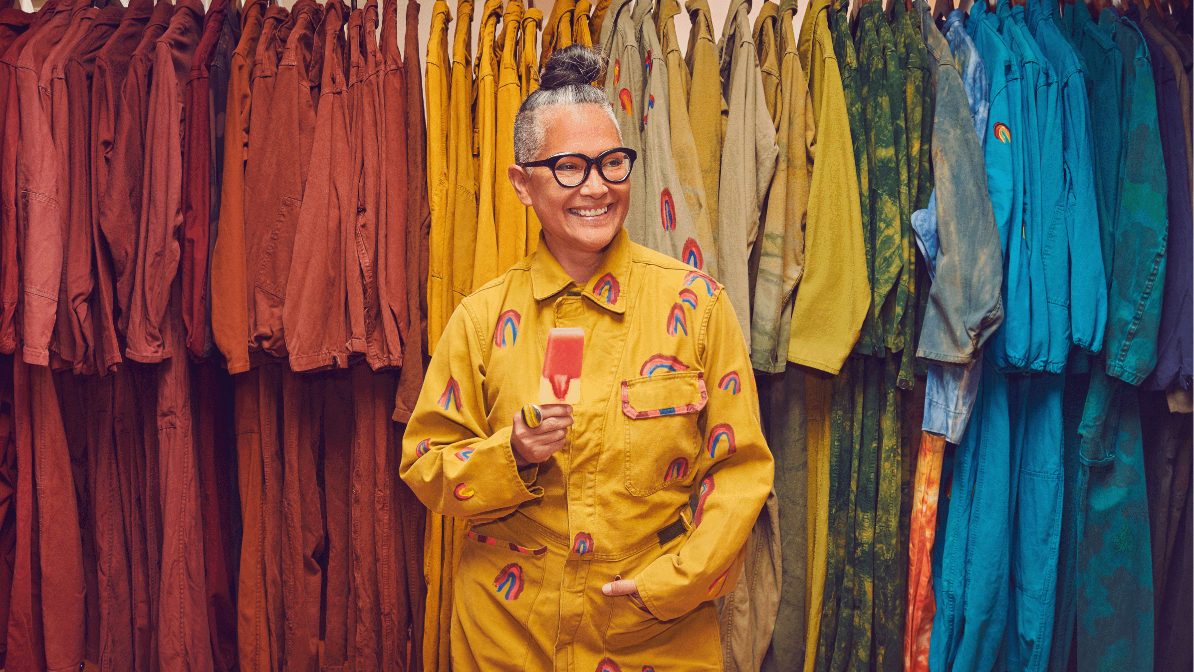 Amy Yeung from Orenda Tribe in front of a colorful line of dresses from the brand.