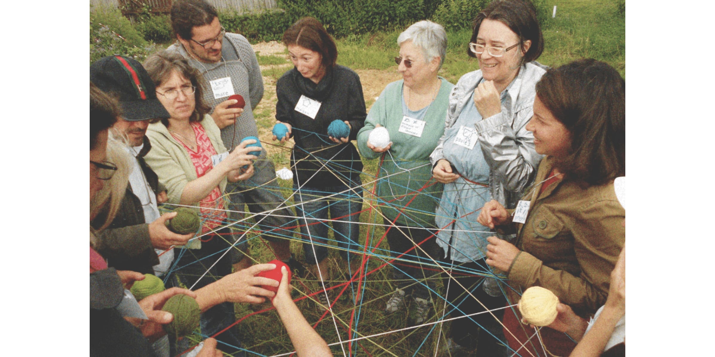 Participants at a Green Samaritans workshop hold balls of yarn criss-crossed together. Photo courtesy of Green Samaritans.