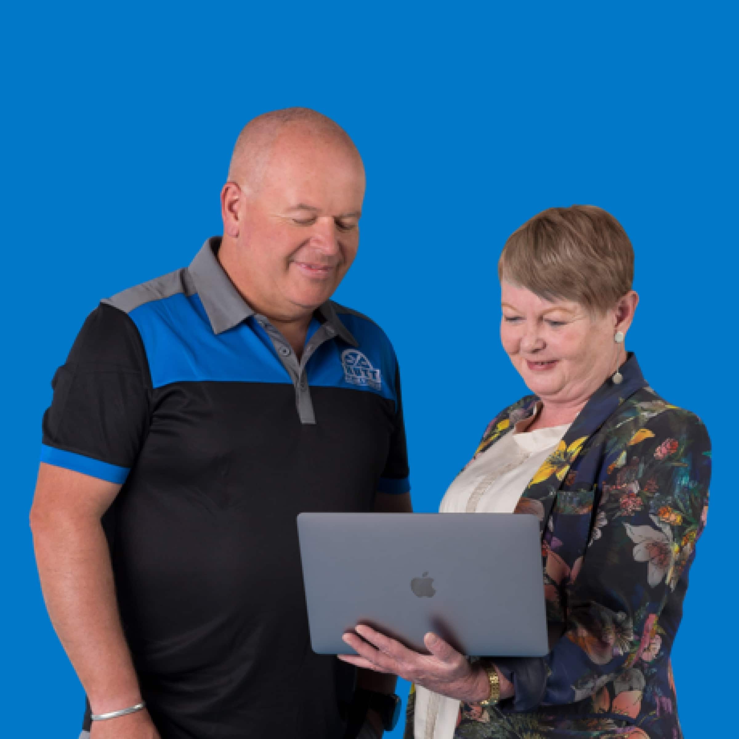 A bookkeeper shows a smiling tradesperson how to see their business figures in Xero’s accounting software on a laptop.