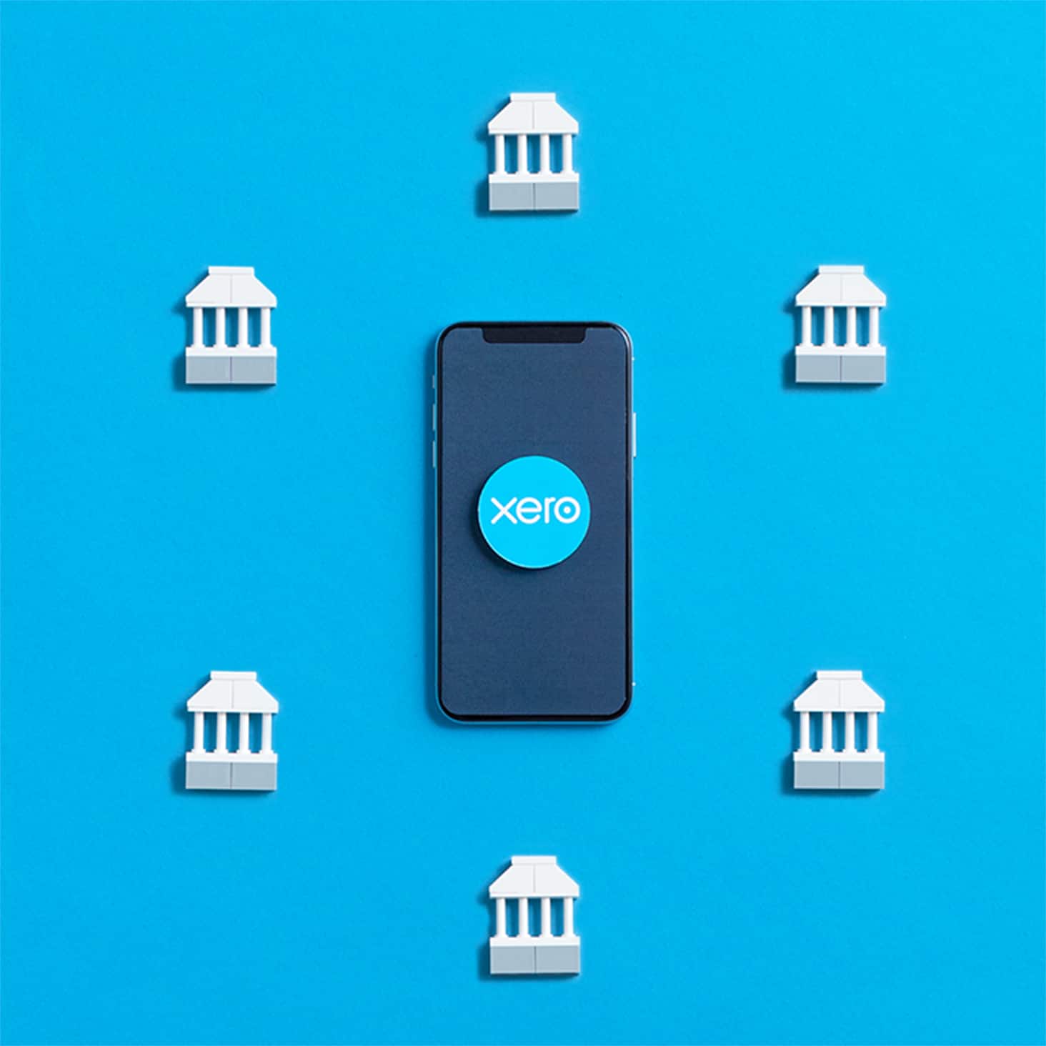 Icons of bank buildings surround a mobile phone where the Xero app receives bank feeds.