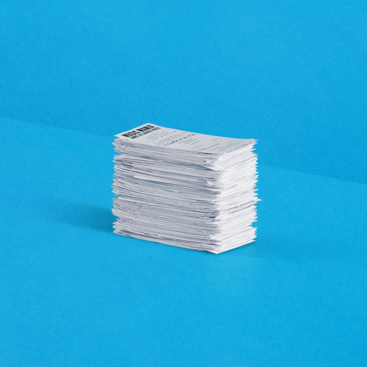 A large pile of receipts for employee expense claims are neatly stacked in a pile.