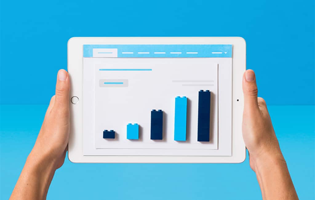 A Xero customer holds a tablet showing a bar chart in Xero’s accounting projection software.